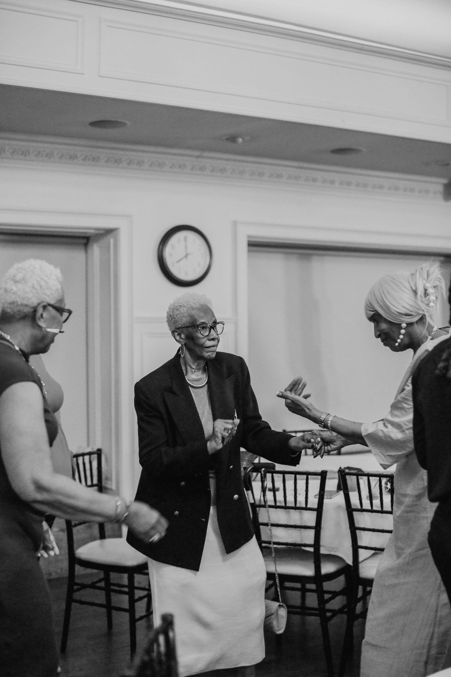 Black and white photo of wedding guests having animated conversation at reception.