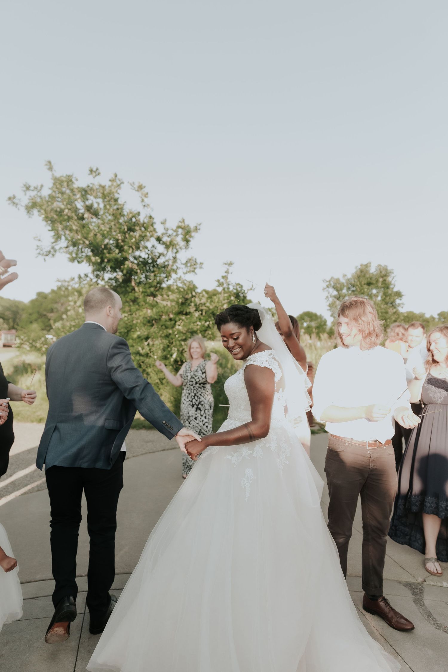 Joyful celebration during outdoor wedding ceremony with guests cheering.