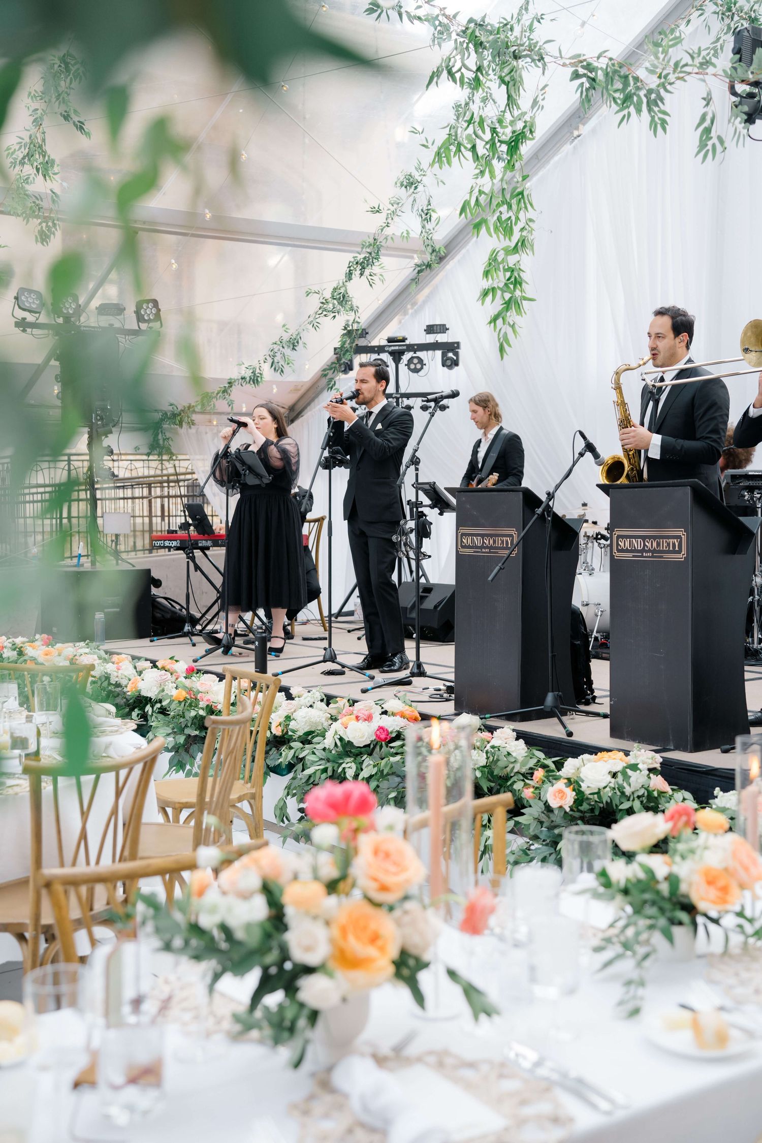 Arrabelle Vail Wedding Venue - Live jazz band performing at an elegant outdoor wedding reception under a floral tent with peach roses.