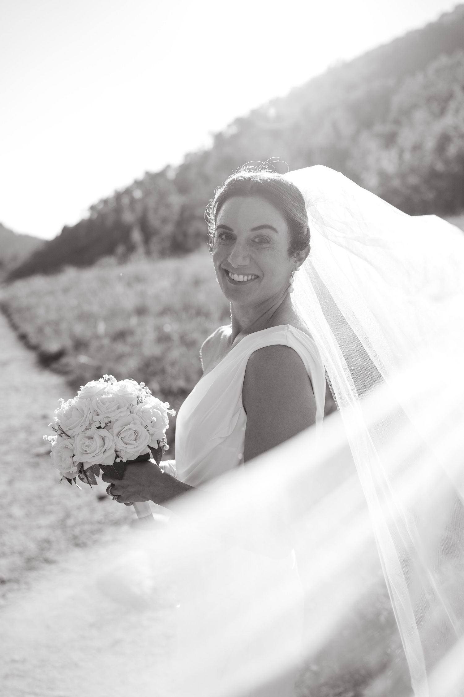 Ethereal bridal portraits in soft natural light with white veil and floral bouquet details.