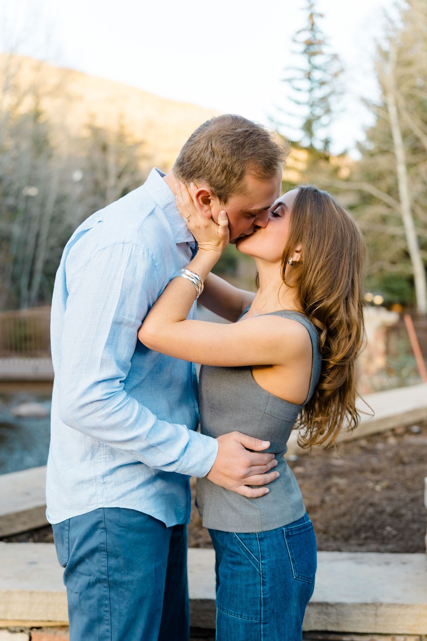 A romantic sequence of embraces and kisses set against a mountain backdrop at sunset.