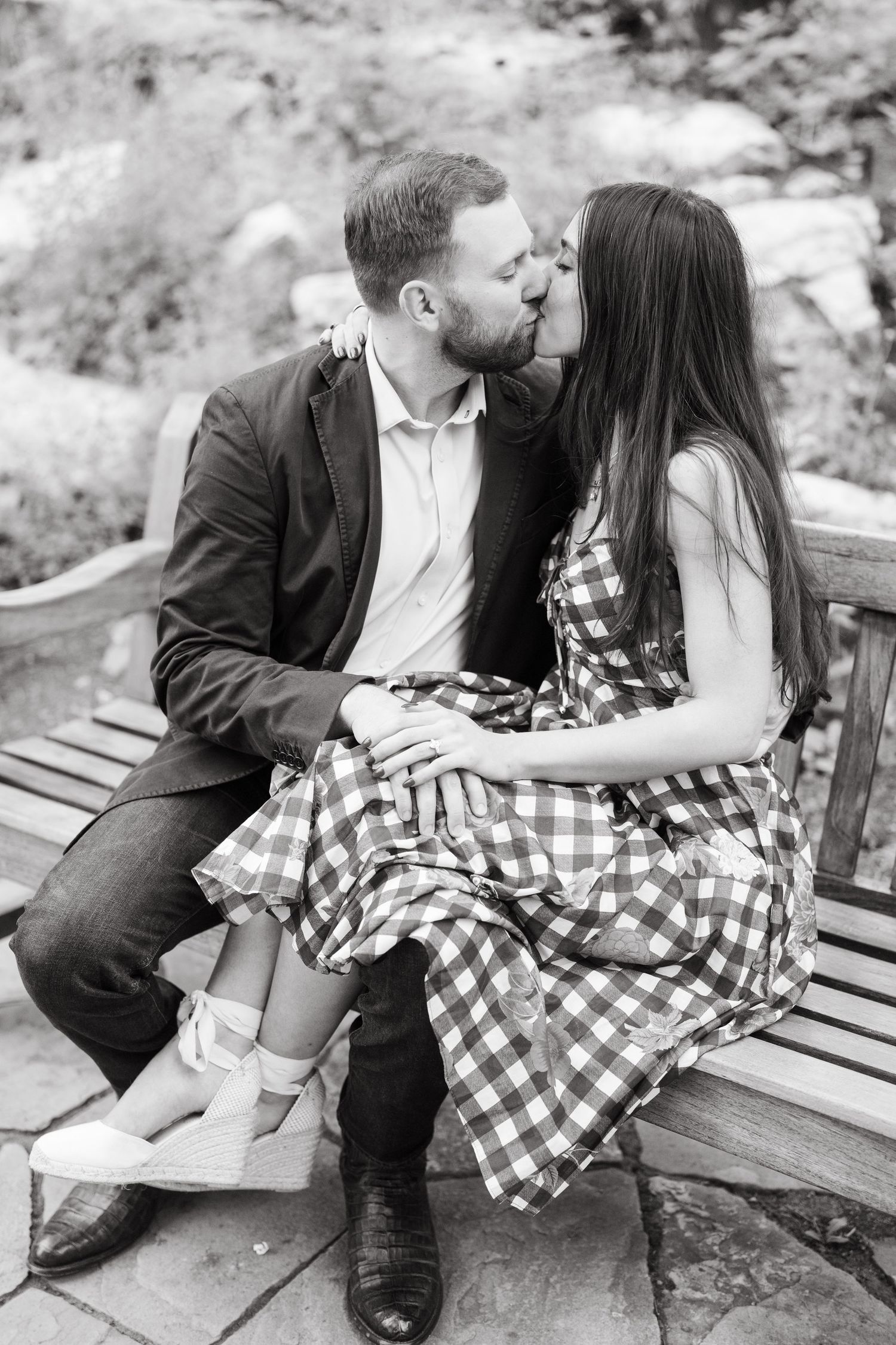 A romantic black and white photo sequence shows a couple sharing sweet moments while sitting together on a wooden bench.