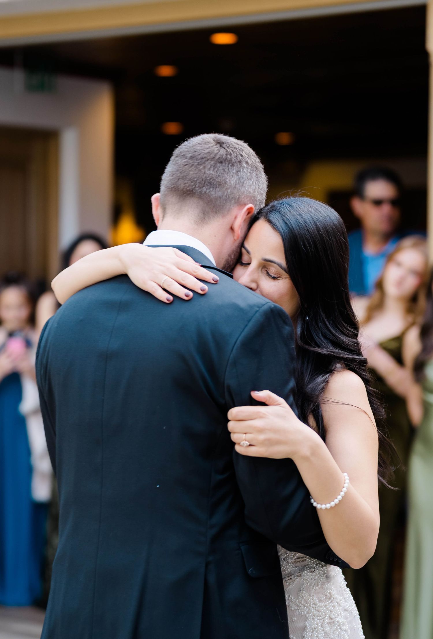 Bride and groom share an emotional first dance embrace at their wedding reception.