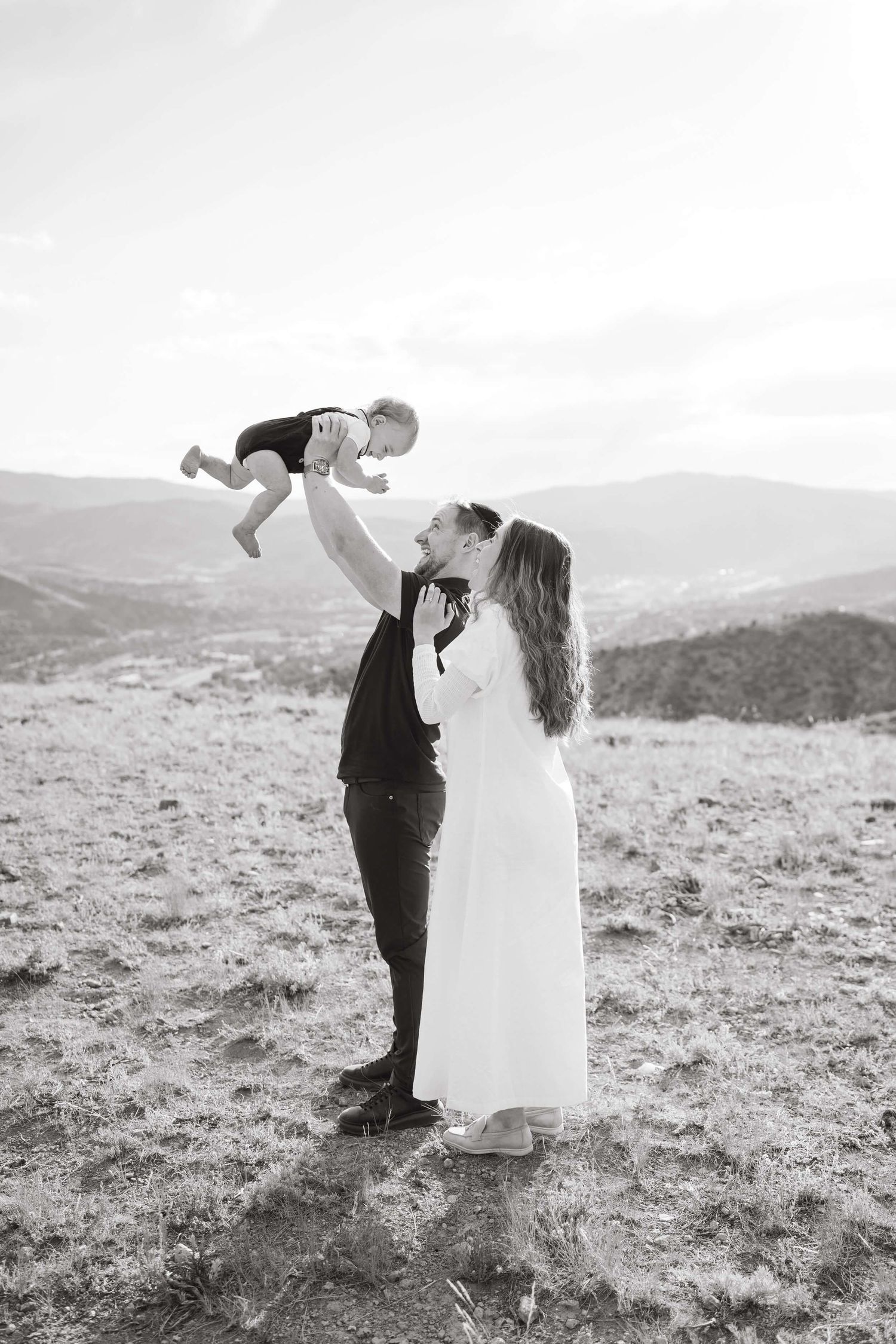 A romantic black and white wedding photo sequence showing a couple dancing together on a hilltop.