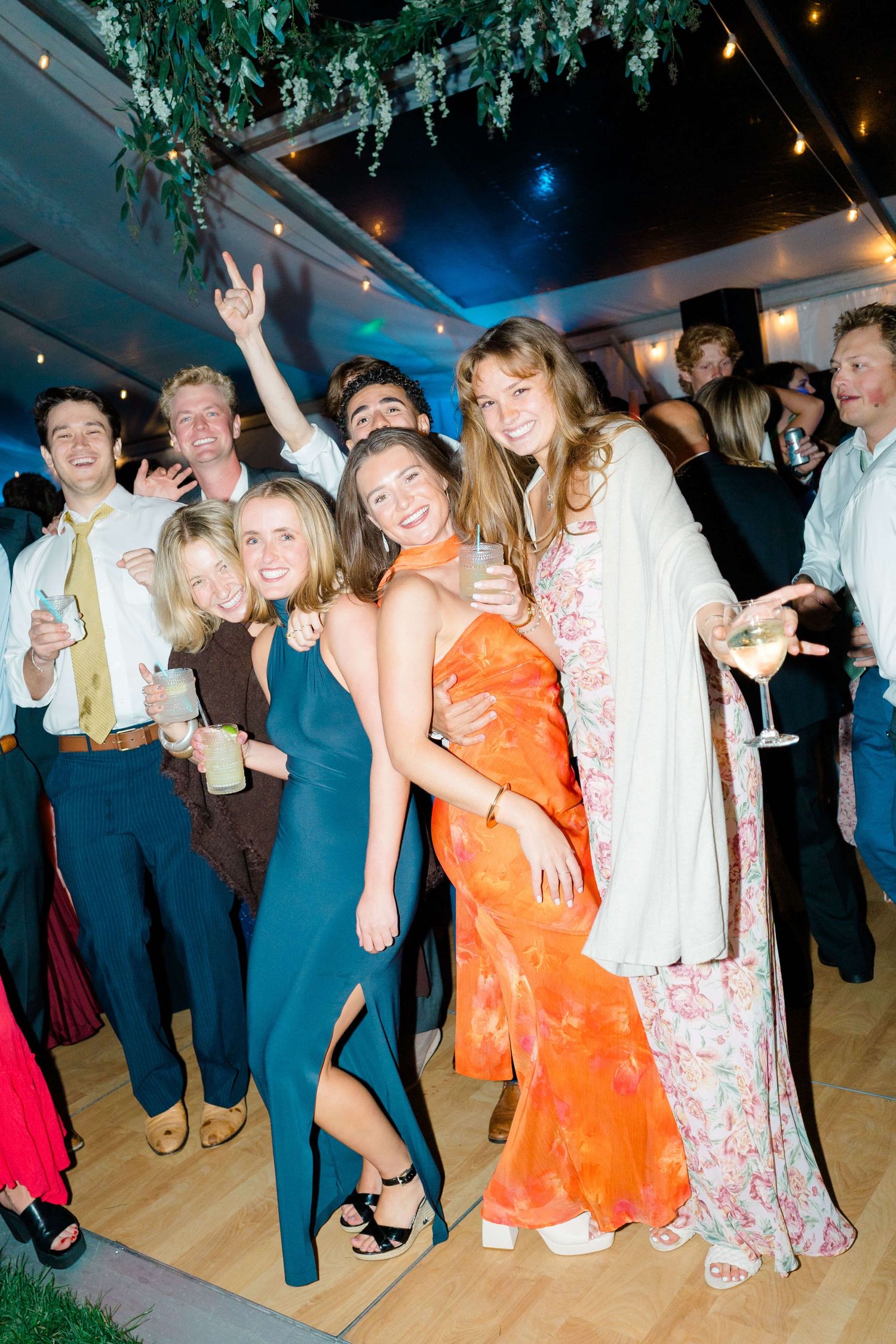 Party guests dancing and socializing on a dance floor at a festive evening event with blue lighting at vail wedding.