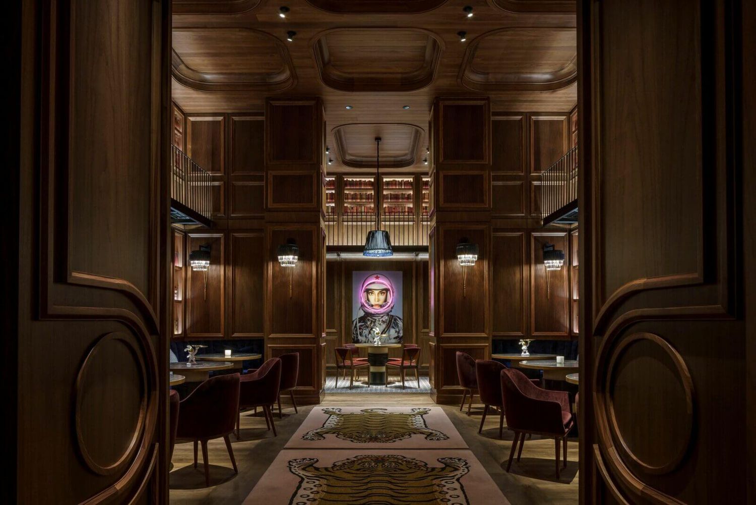 Chasing Rabbits Vail Wedding Venue - Elegant dark wood-paneled dining room with moody lighting, velvet chairs, ornate rugs.