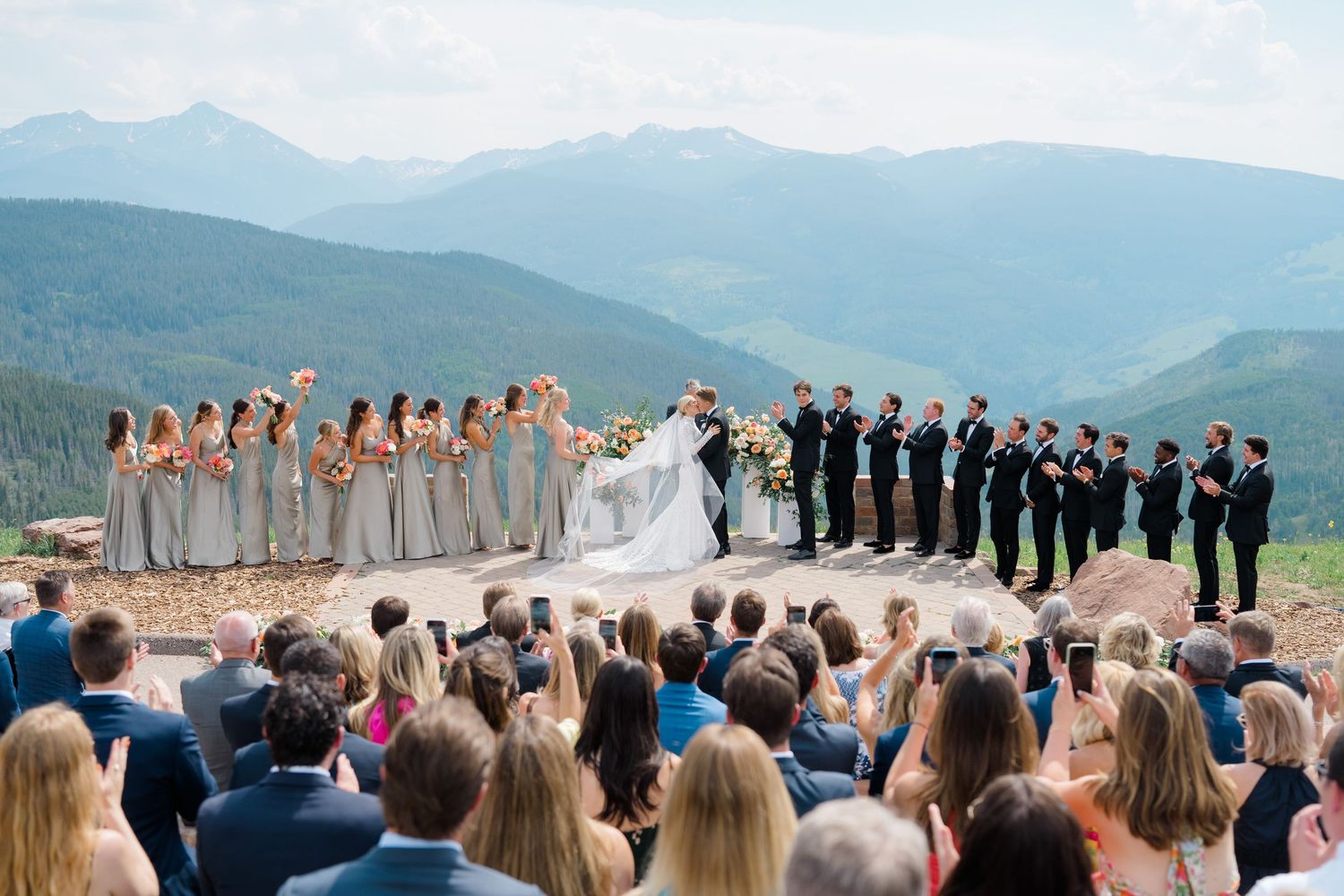 Wedding ceremony overlooking a scenic mountain landscape with guests gathered to witness the special moment at vail wedding.