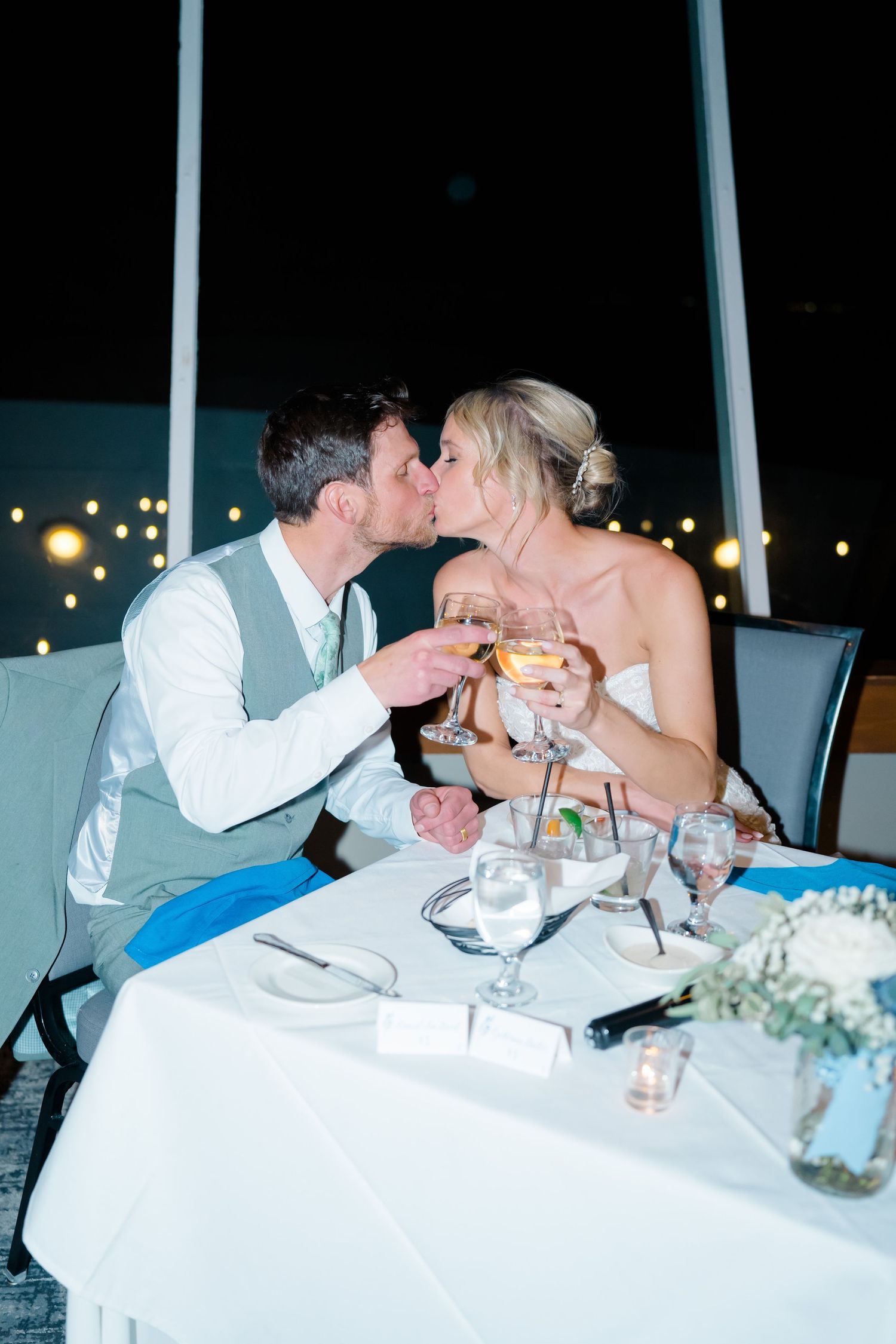 couple kissing and doing cheers with their glasses