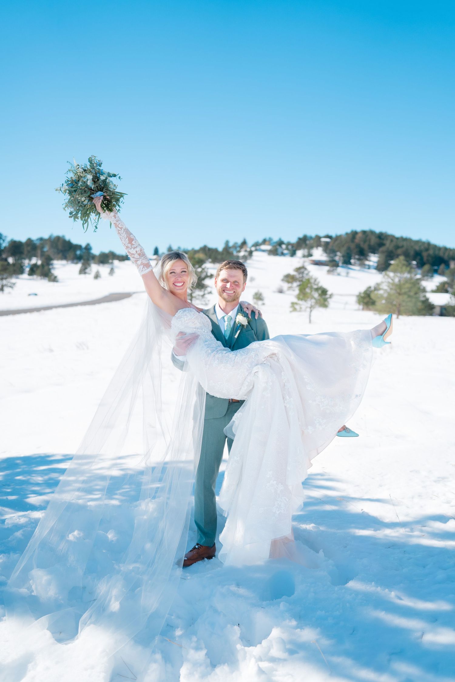 bride holding groom while she throws flowers up in the air celebrating wedding day