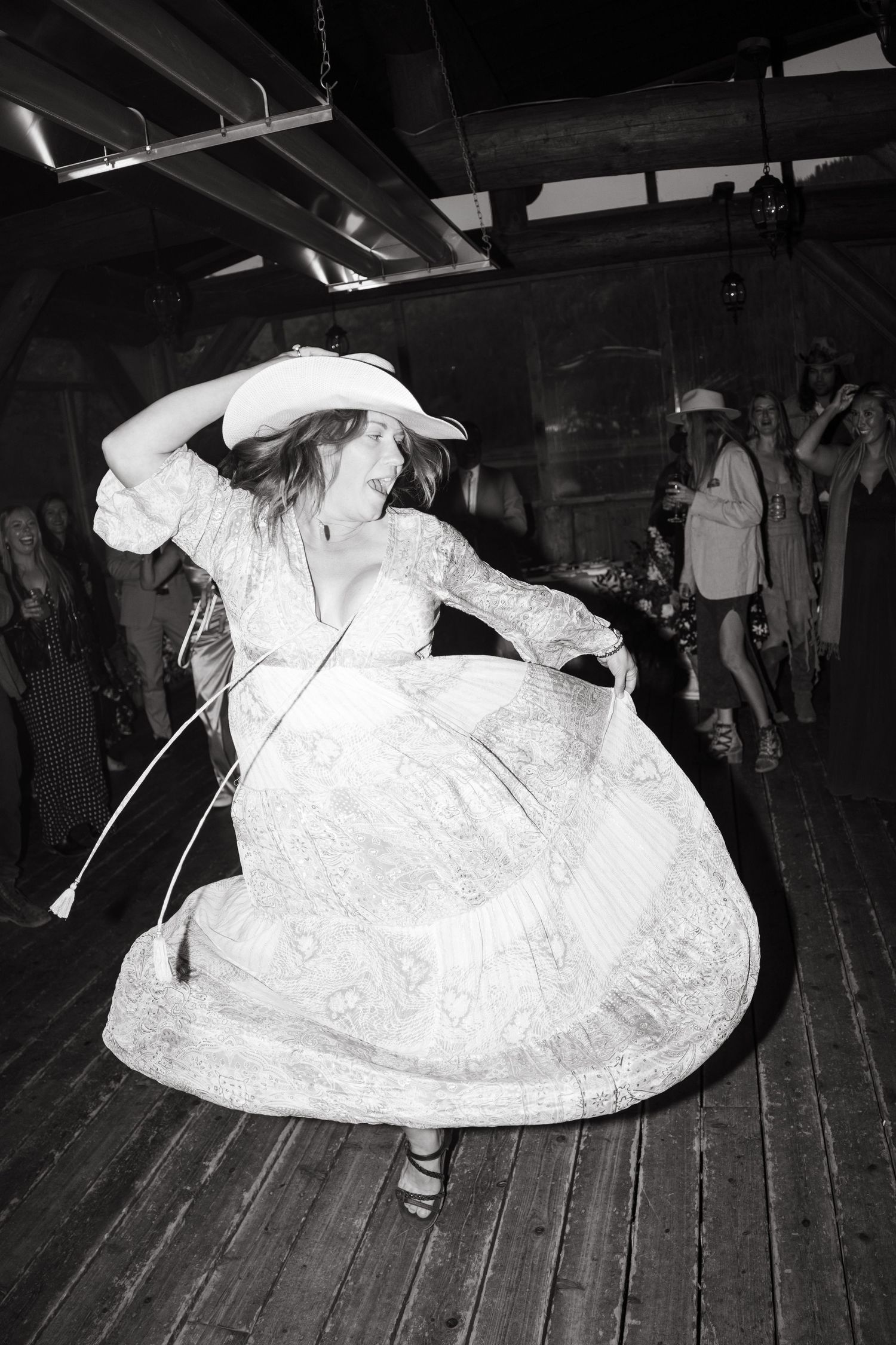 Black and white photo of dancers twirling on a wooden dance floor at Piney River Ranch Wedding.