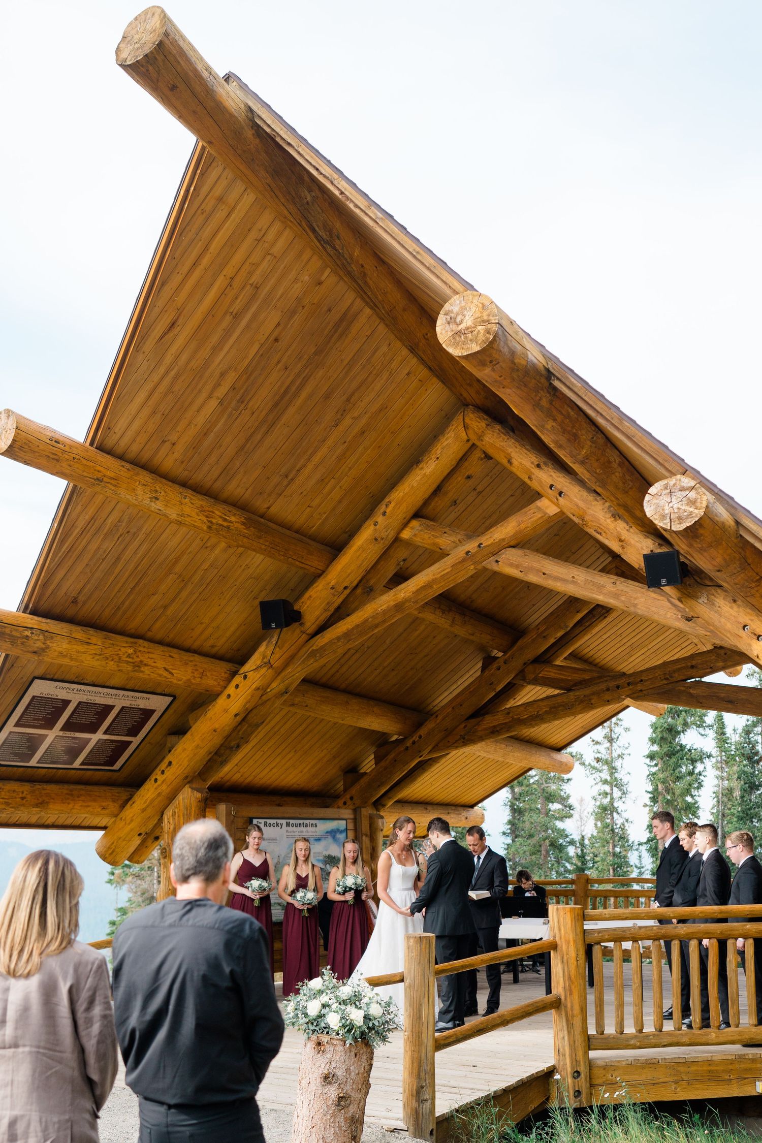 Rustic timber lodge deck with angled wooden roof beams and railings overlooking mountain scenery at copper mountain aerie venue.