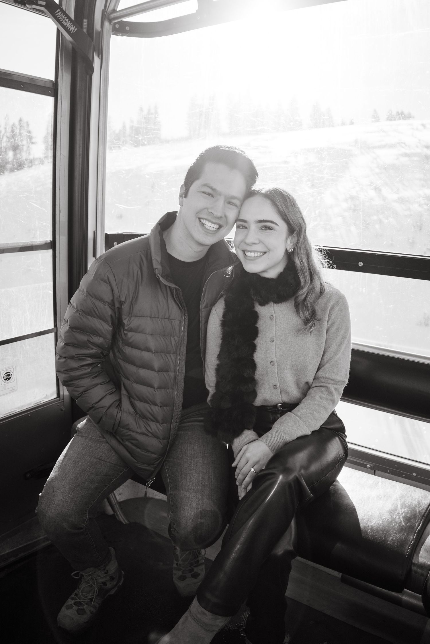 Black and white candid photos of two people laughing together while sitting on a bus or train seat.