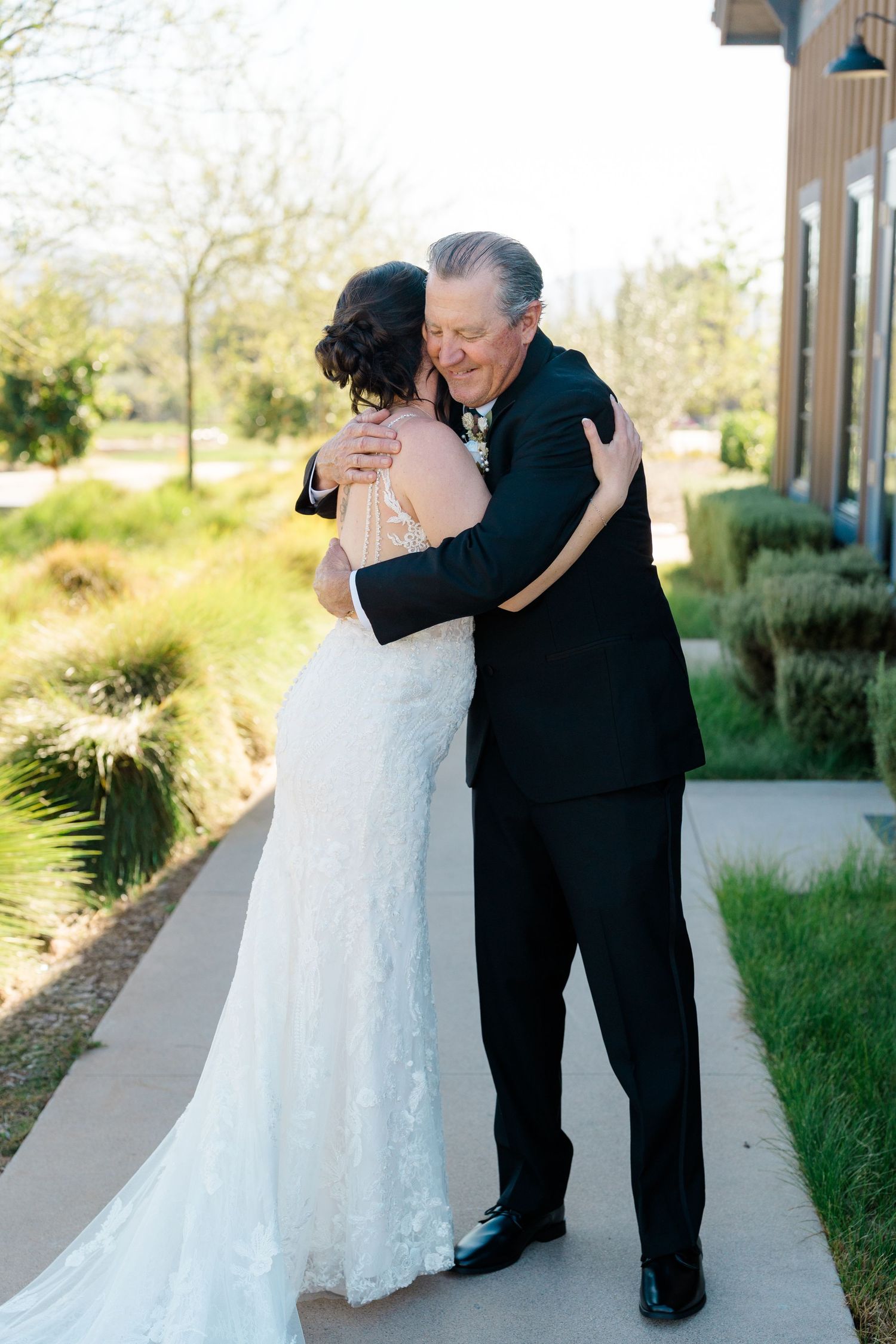 Amber Hart shares an emotional moment with her father on the wedding day at Canopy Grove in Escondido, California, photographed.