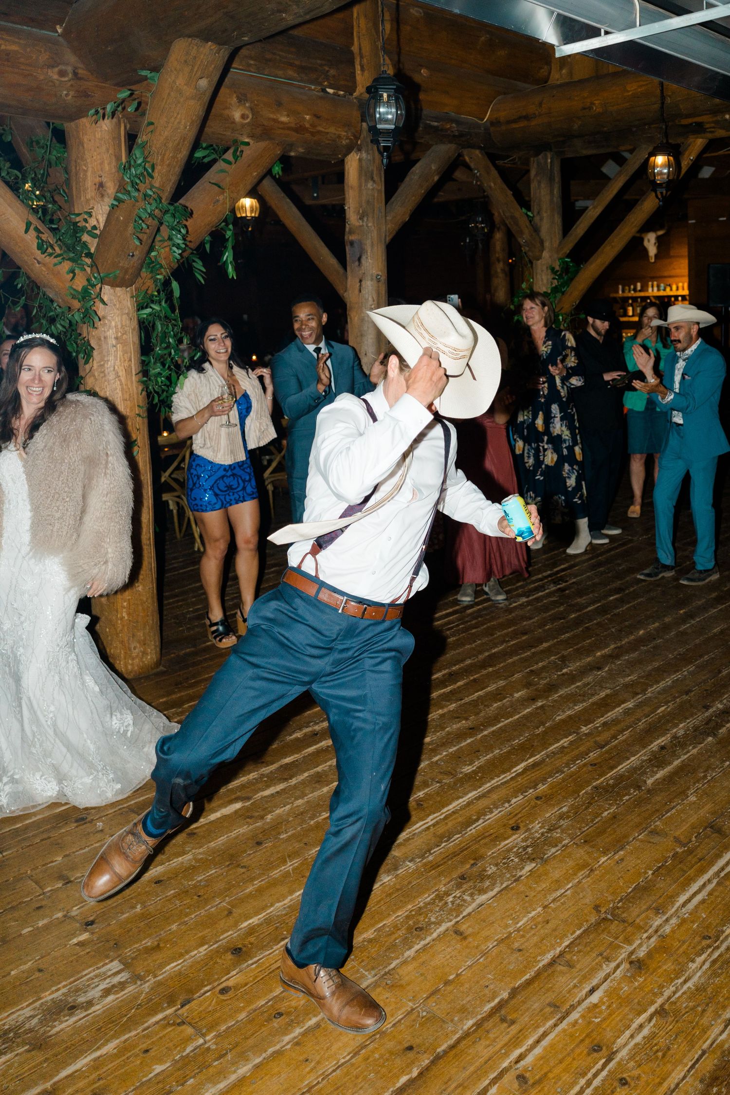 Dancers performing lively swing dance moves in a rustic barn venue with wooden beams and floors at Piney River Ranch Wedding.