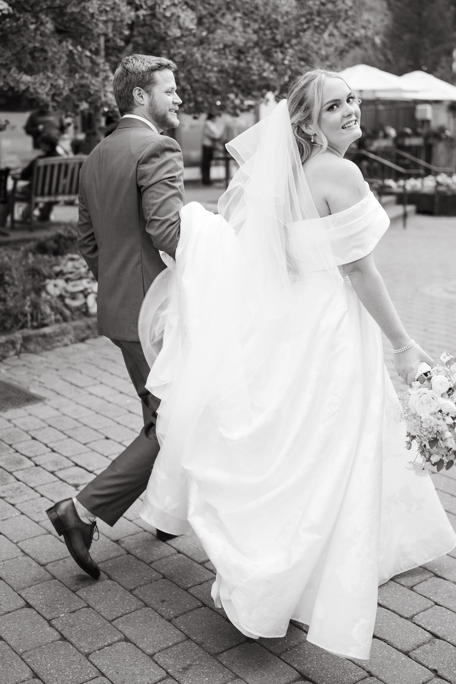 A couple dancing on stone pavers, with the bride's white dress flowing gracefully in motion.