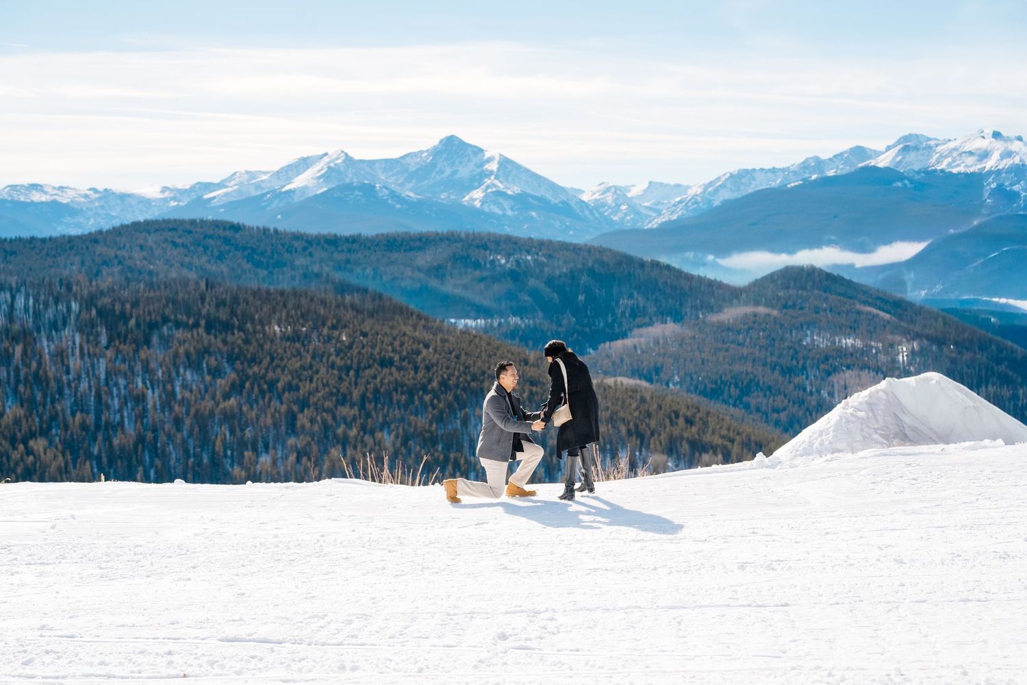 A panoramic view of snow-covered mountain peaks and valleys stretches across multiple connected landscape photos.