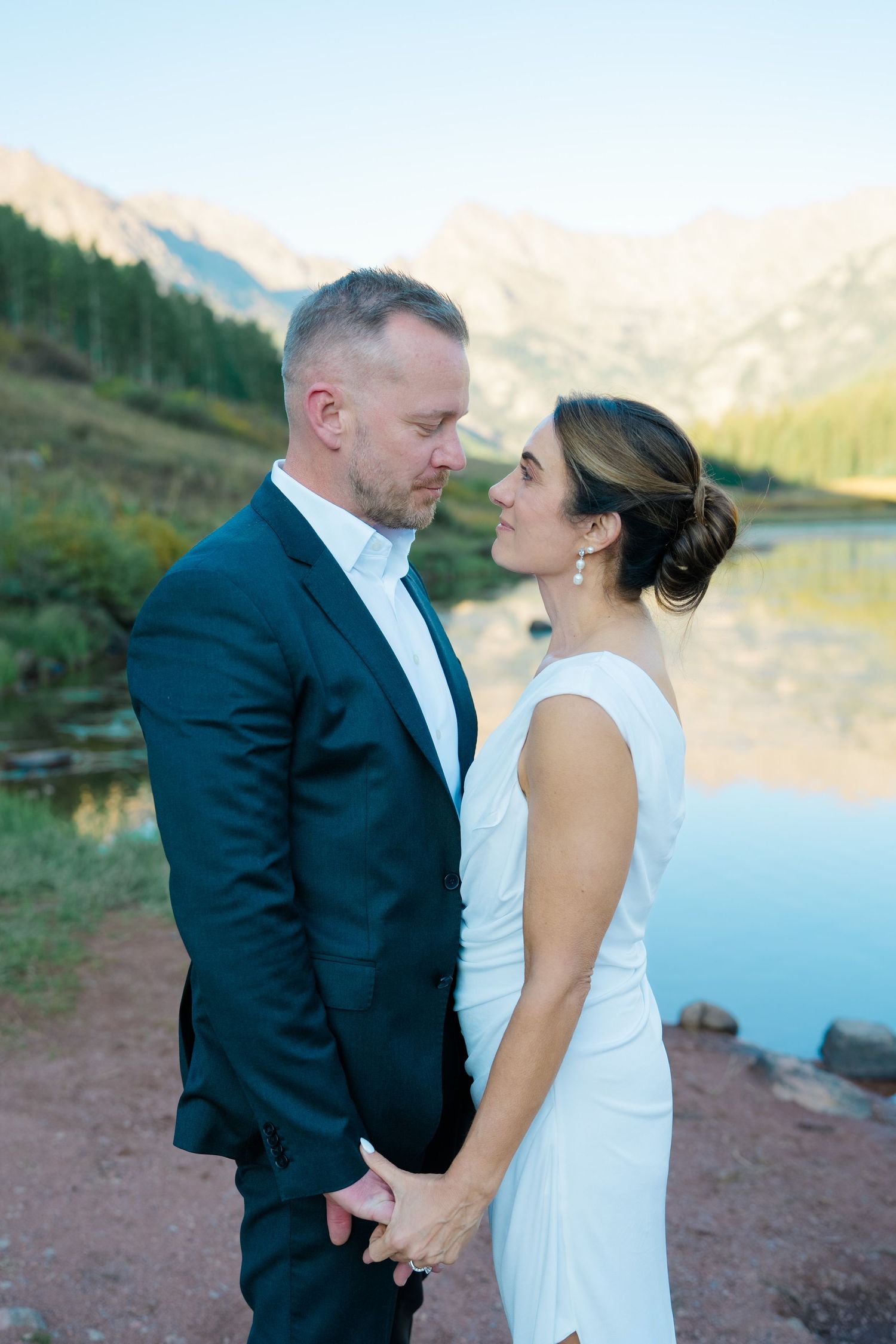 bride and groom holding hands in front of piney river ranch