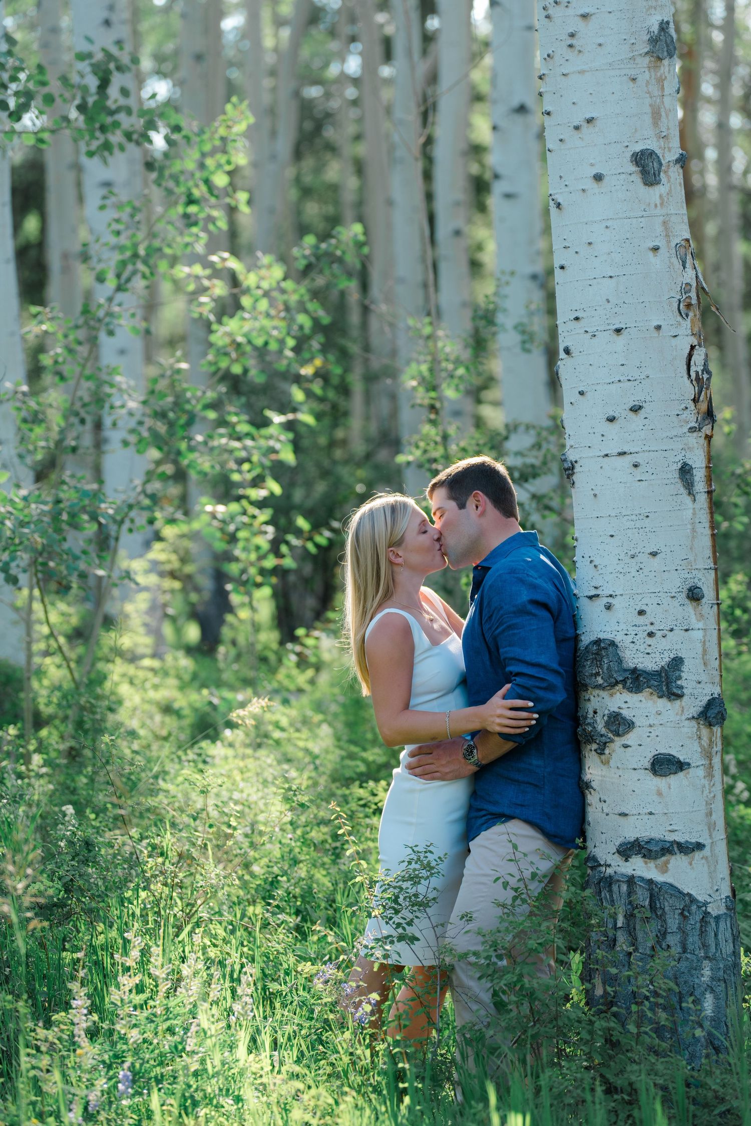 guy and girl kissing in the aspen grove