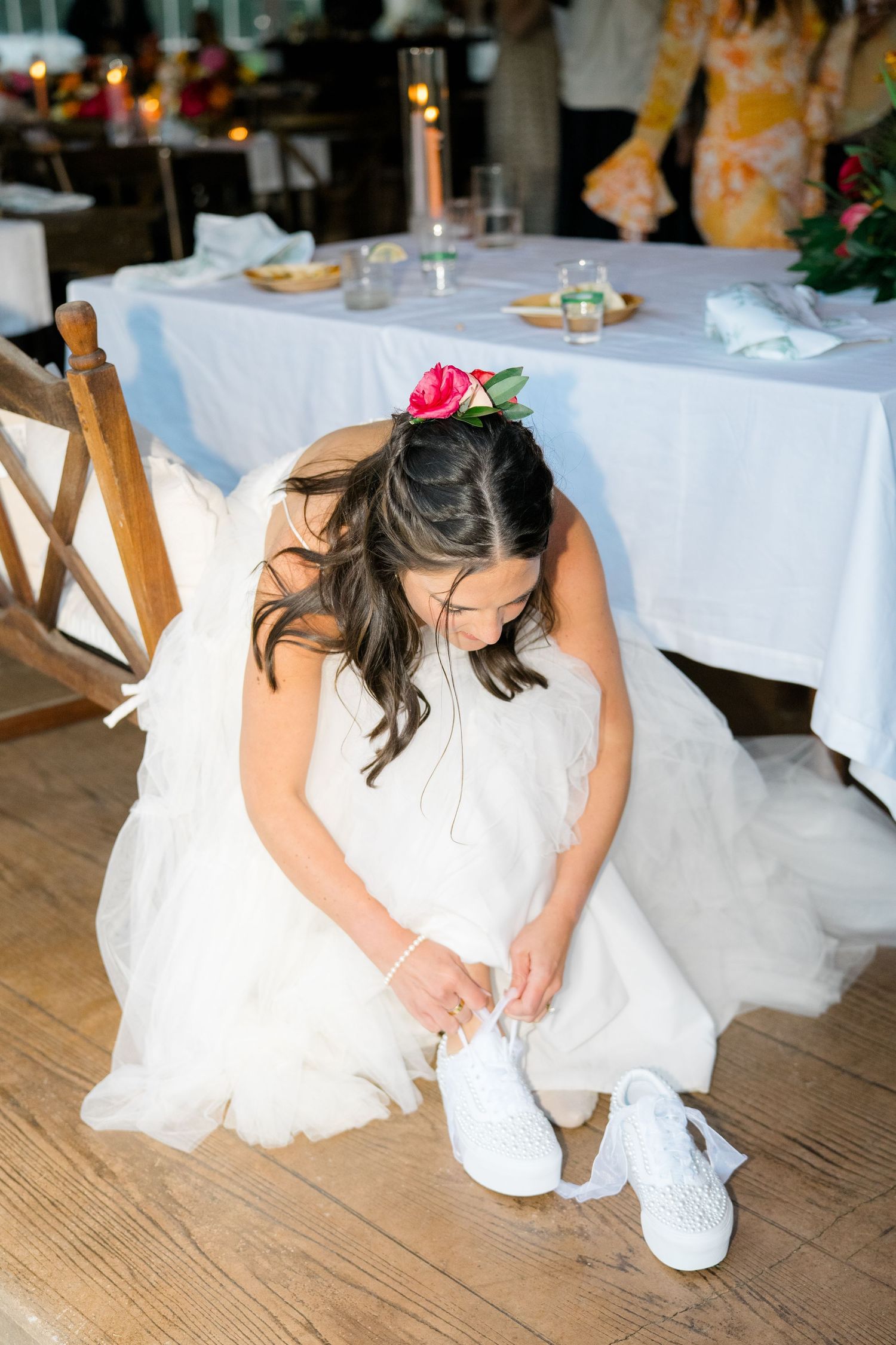 Close-up of bride showing off her white sneakers under wedding dress.