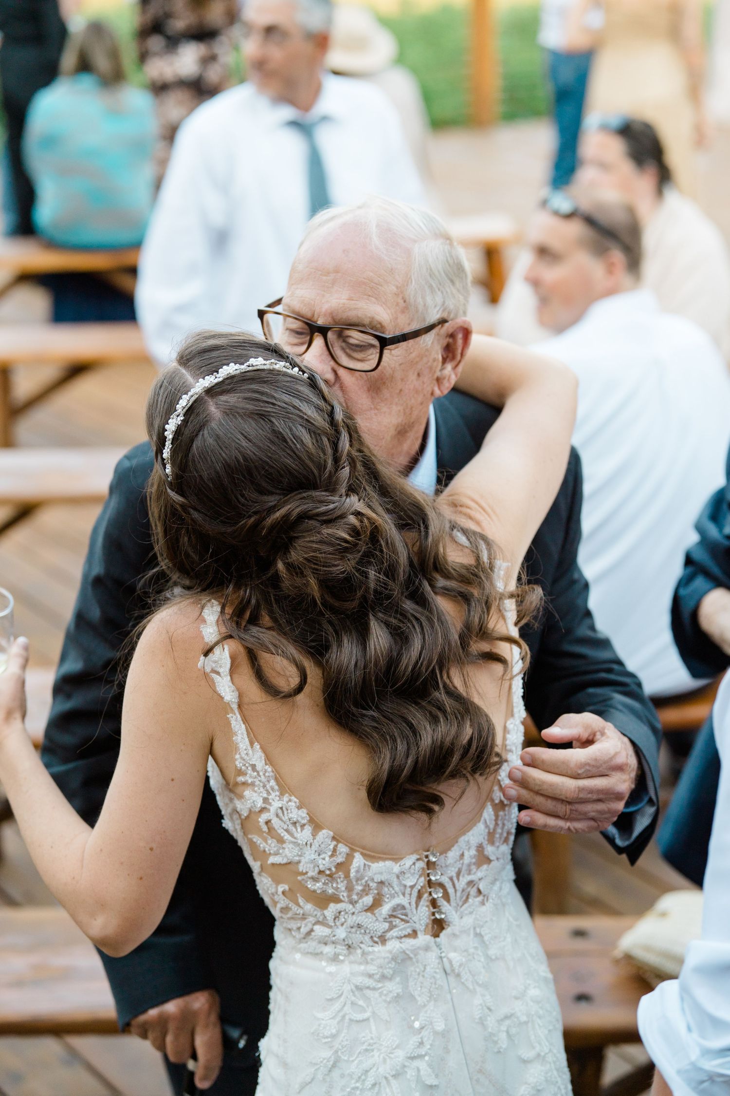 Wedding celebration with guests gathered around tables at an outdoor venue.