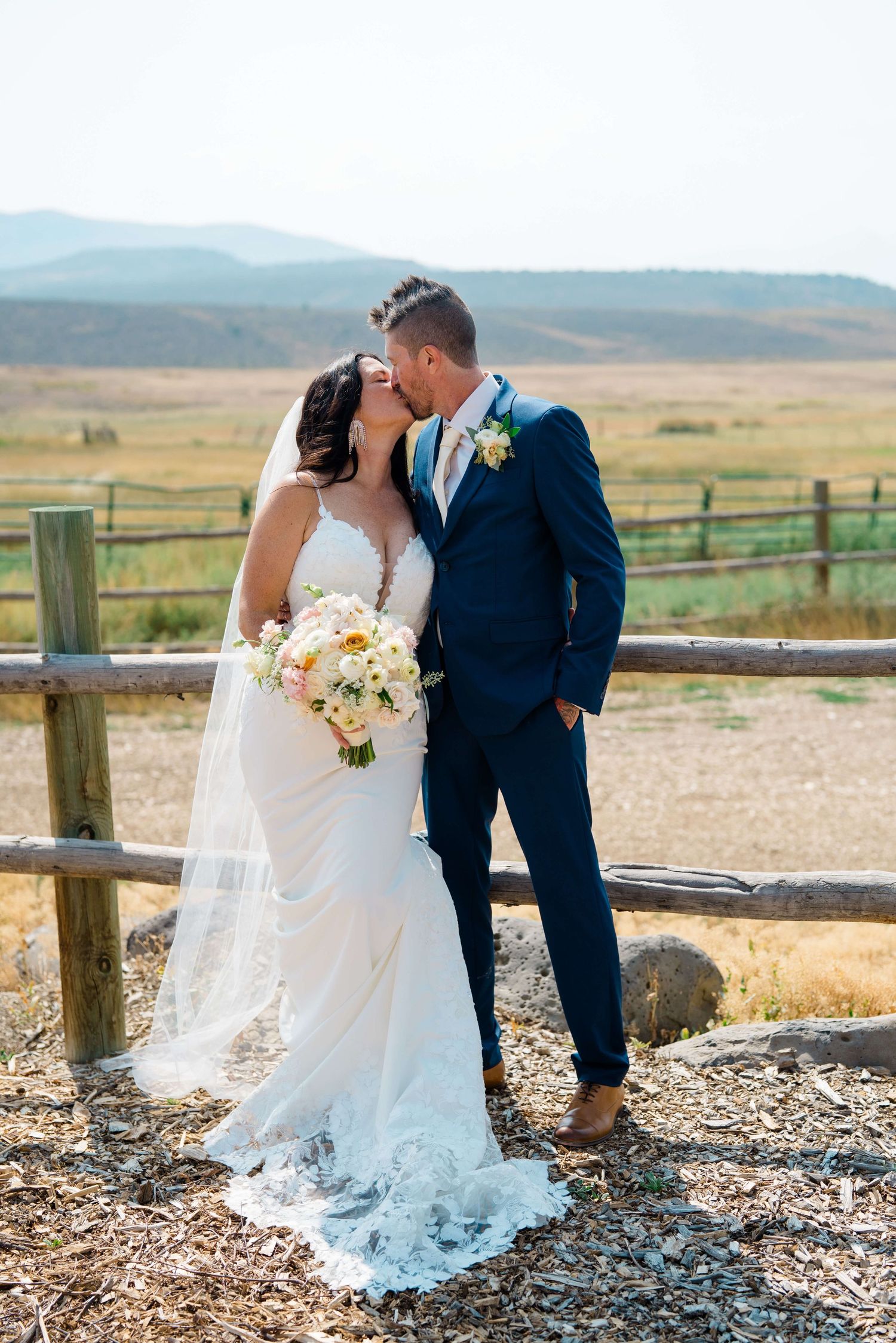 4 Eagle Ranch Vail Wedding Venue - Bride and groom share a kiss outdoors, she in lace gown with veil