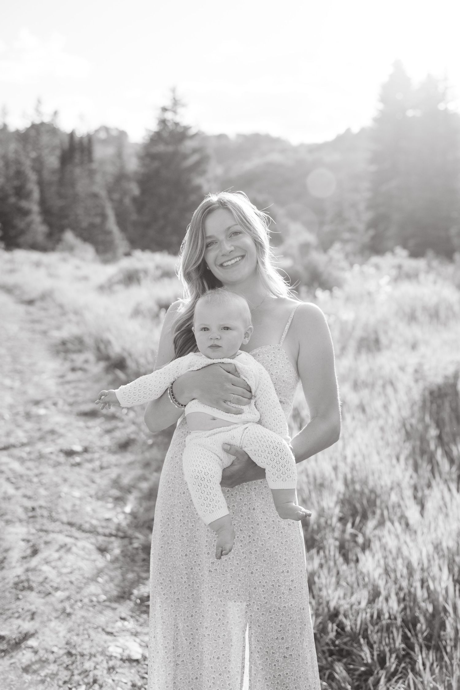 A sweet outdoor portrait session in a sunlit meadow with soft black and white tones.