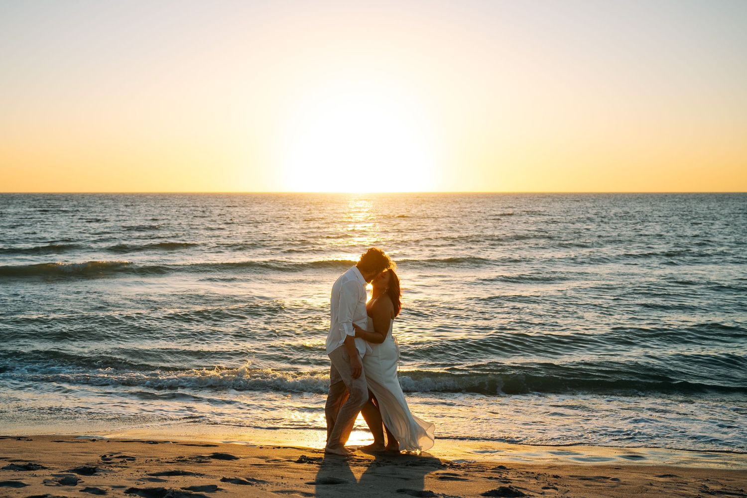 guy and girl kissing with the sunset in the back