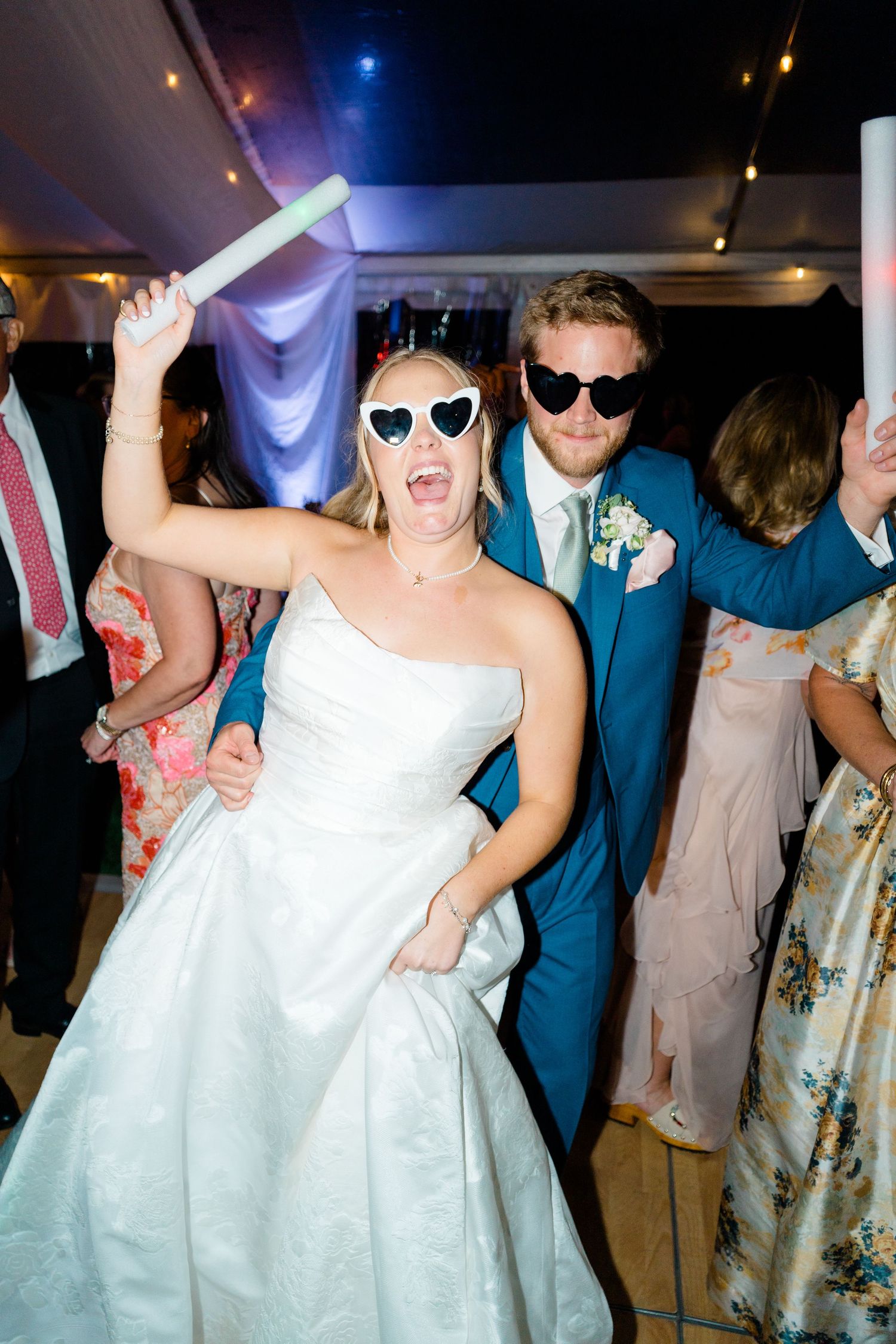 Wedding reception dance party with guests wearing sunglasses and formal attire under dim lighting in vail colorado wedding.