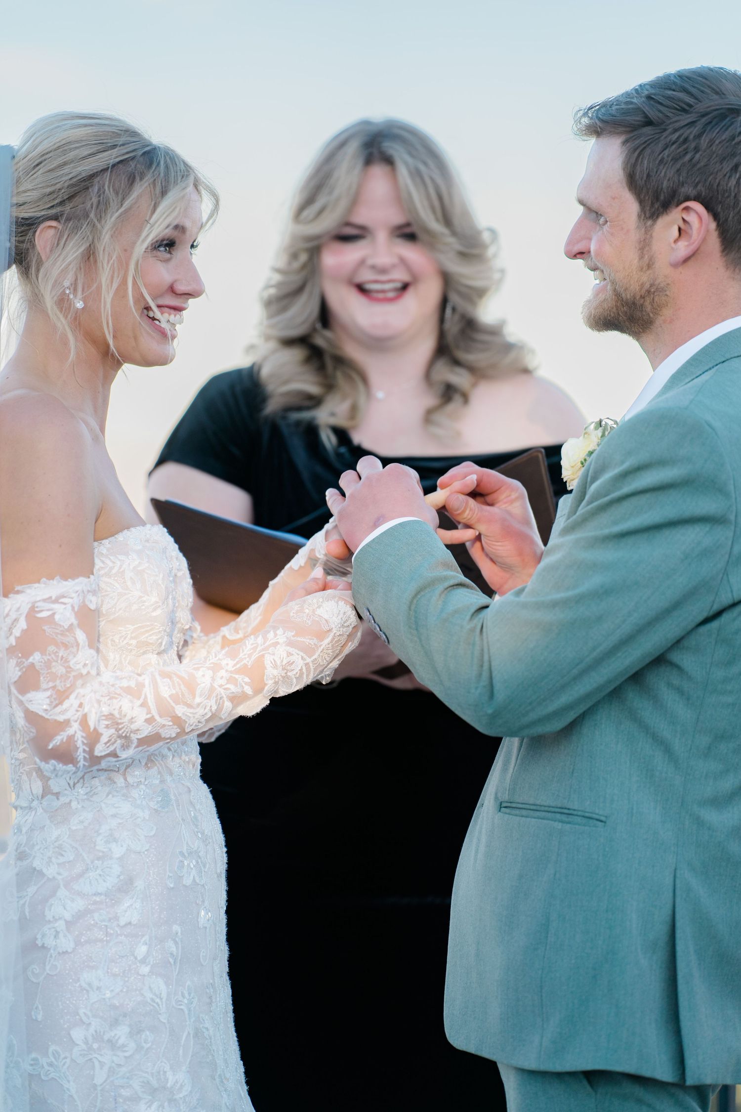 couple puts rings on fingers after getting married
