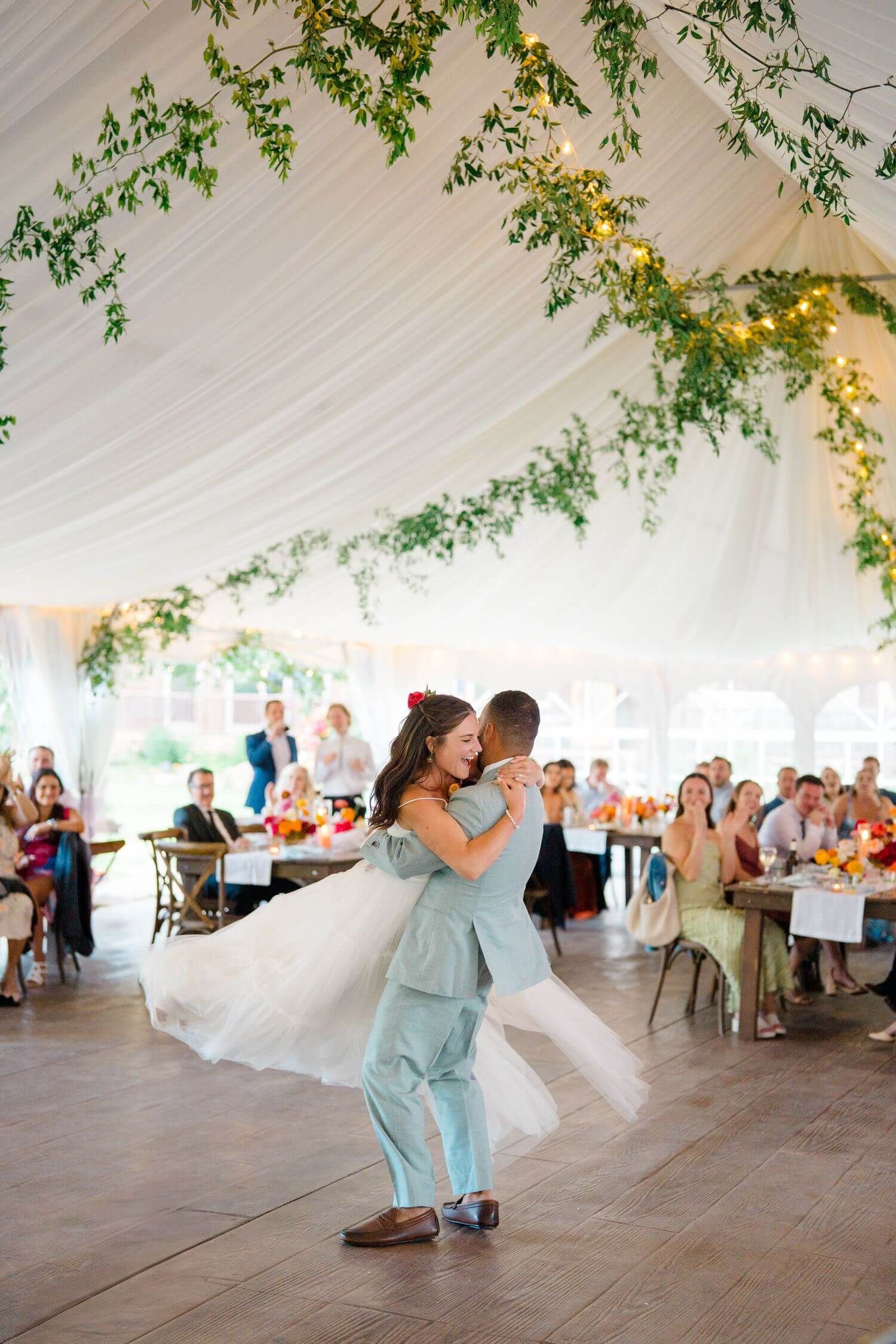Camp Hale Wedding couple performs romantic dance sequence in white tent reception venue with guests watching from tables.