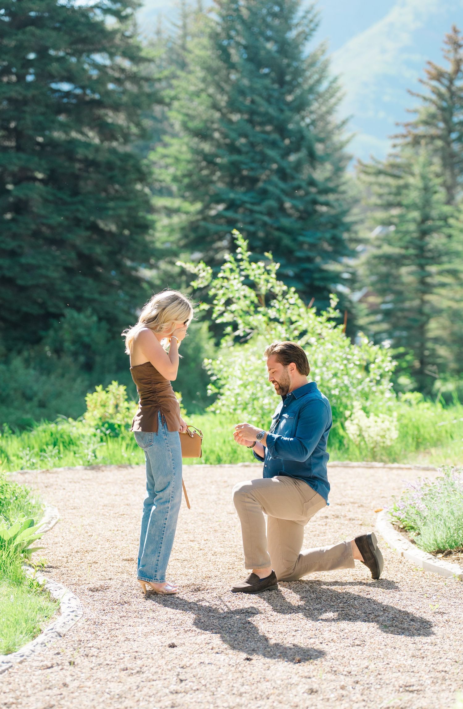 guy down on one knee in the rocks asking his girlfriend to marry him at a spot in vail, colorado proposal.