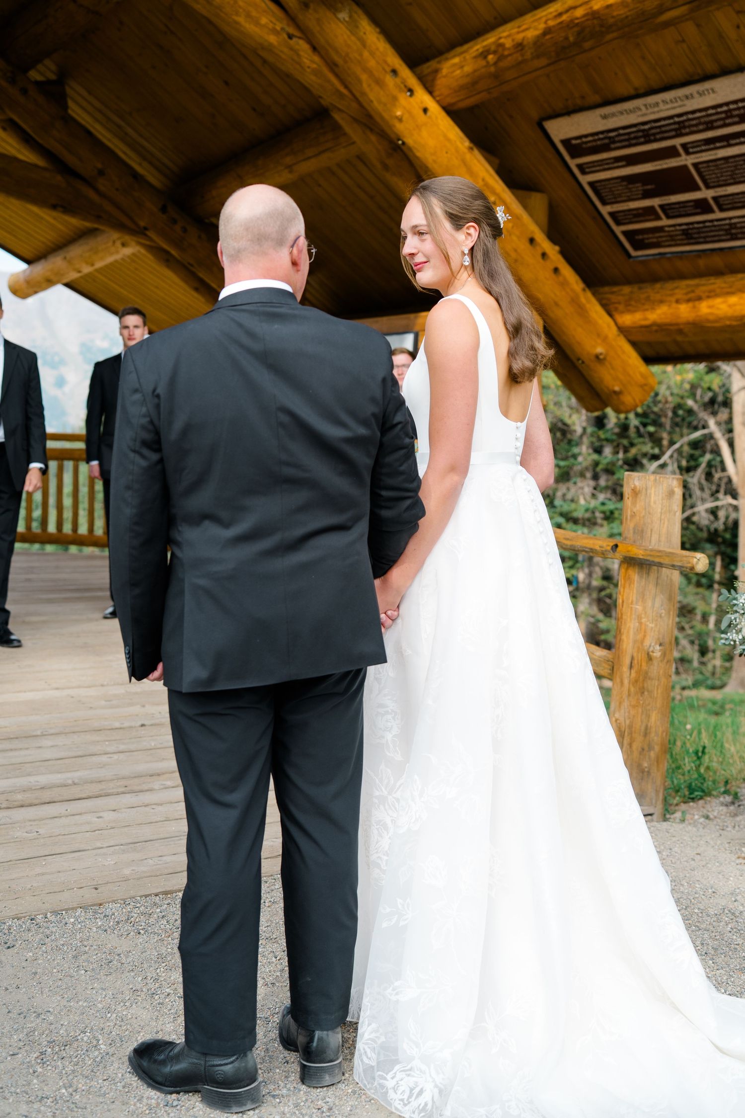 A series of wedding photos showing a couple in formal attire walking and interacting on a rustic wooden deck at copper mountain.