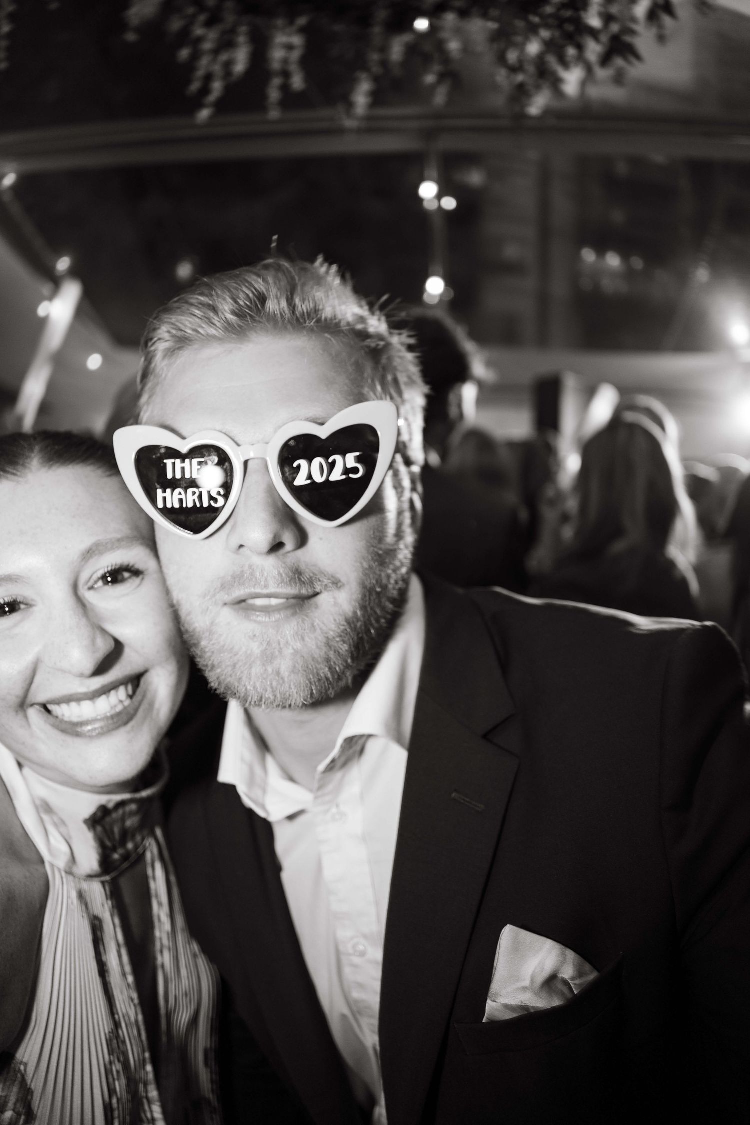 Black and white photo series showing couple posing with heart-shaped props at a celebratory event being a vail wedding.