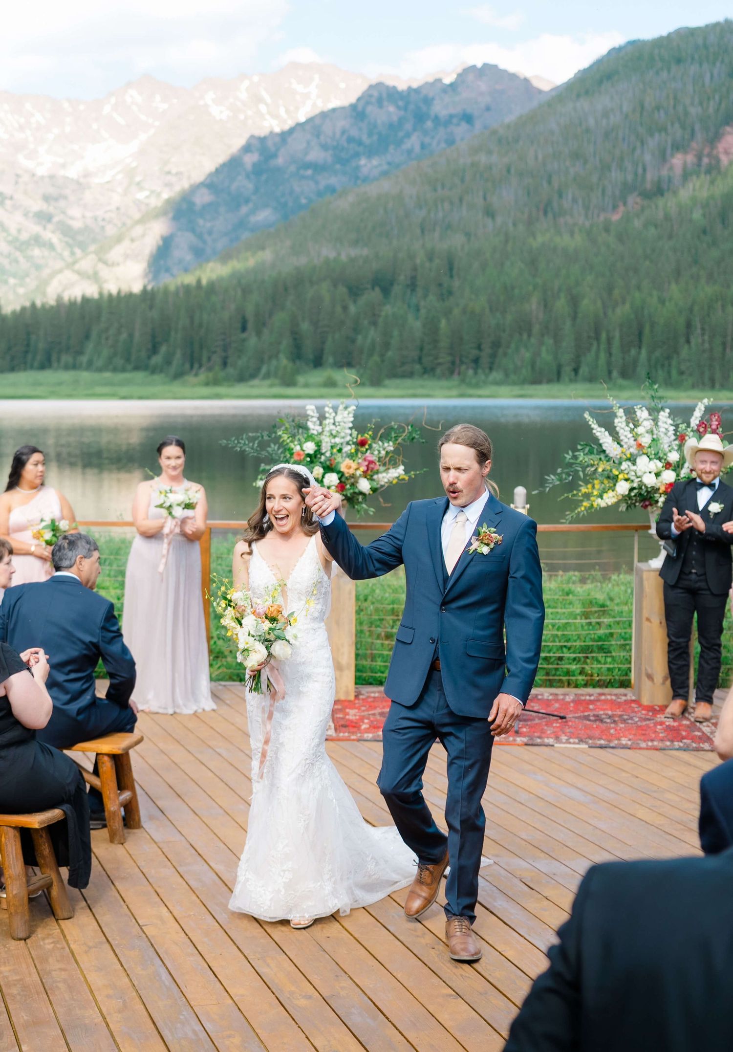 Bride and groom celebrate after outdoor mountain lake wedding at Piney River Ranch.