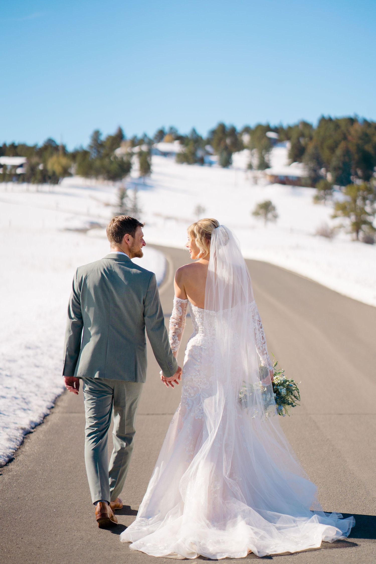 couple holding hands and walking away from photographer