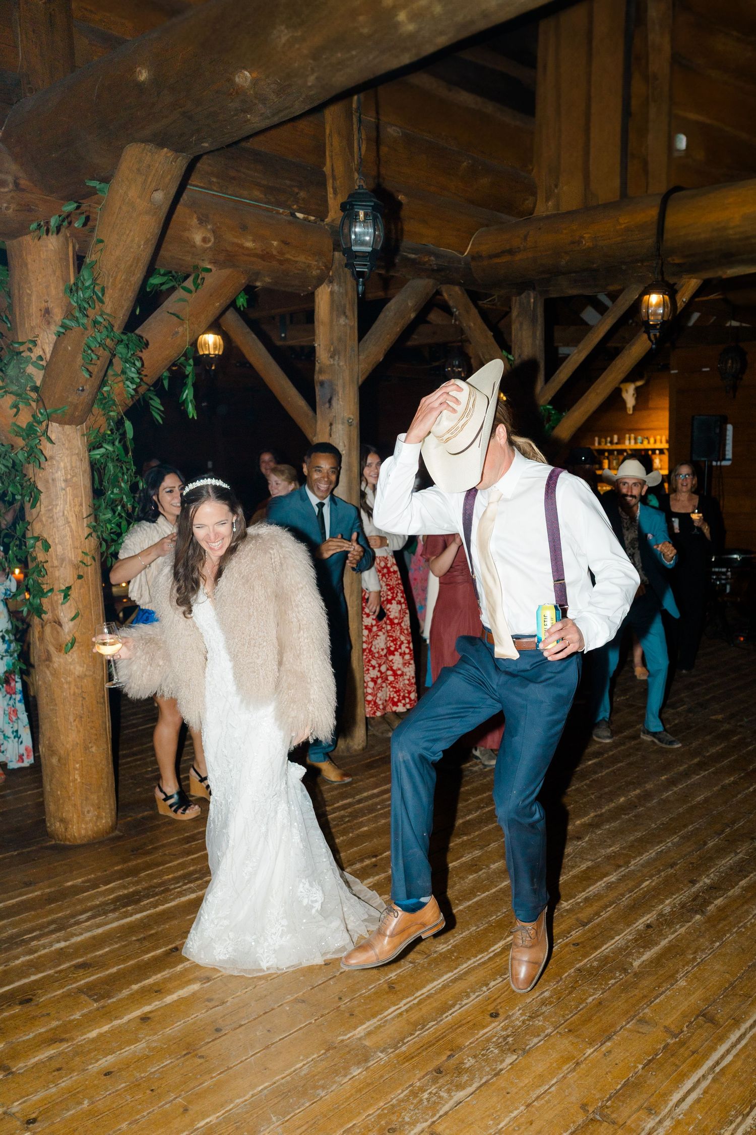 Couples dancing at a rustic venue with wooden beams and floors during a lively celebration at Piney River Ranch Wedding.