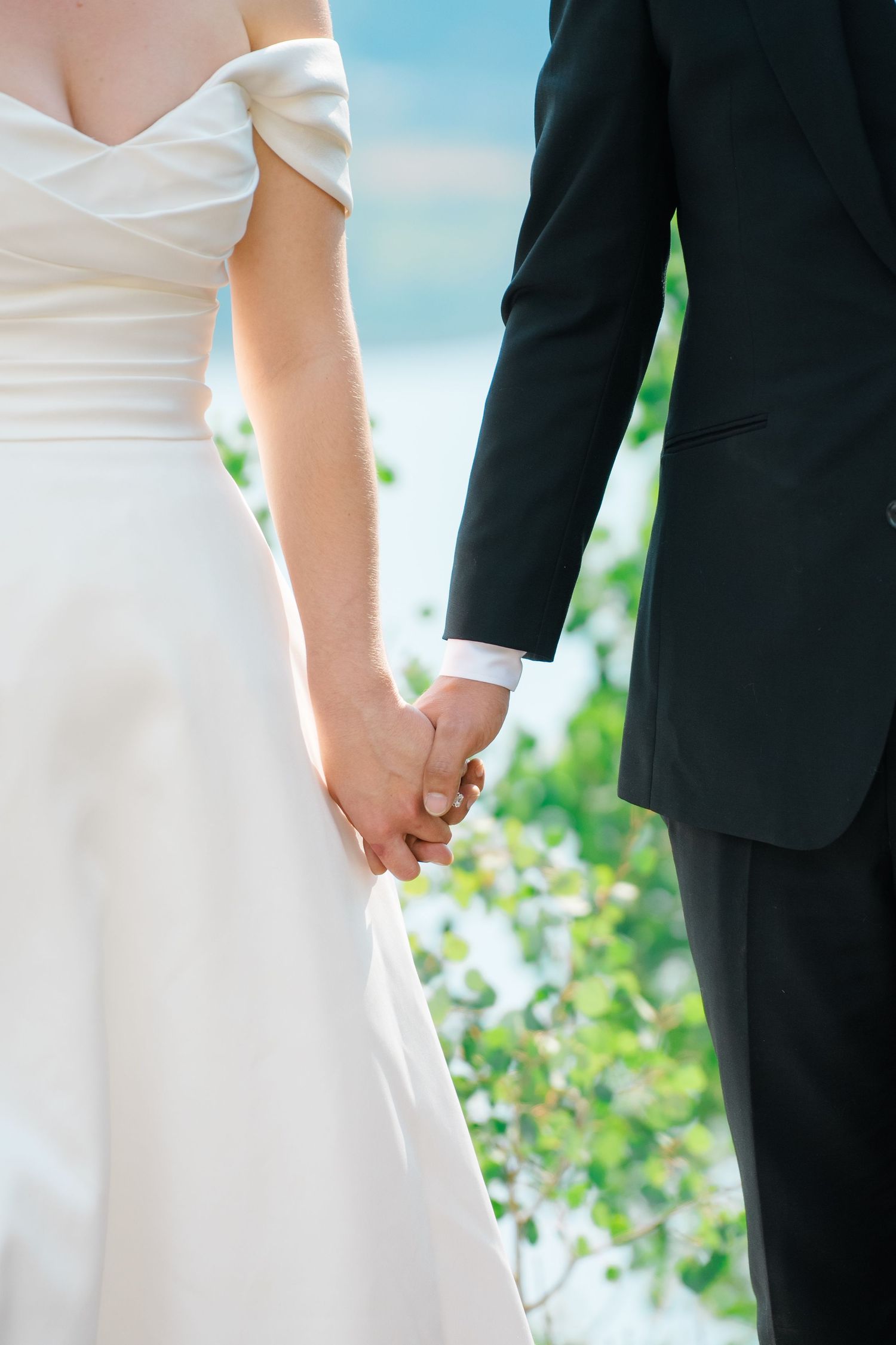 Close-up shots of a couple holding hands during their outdoor wedding ceremony.