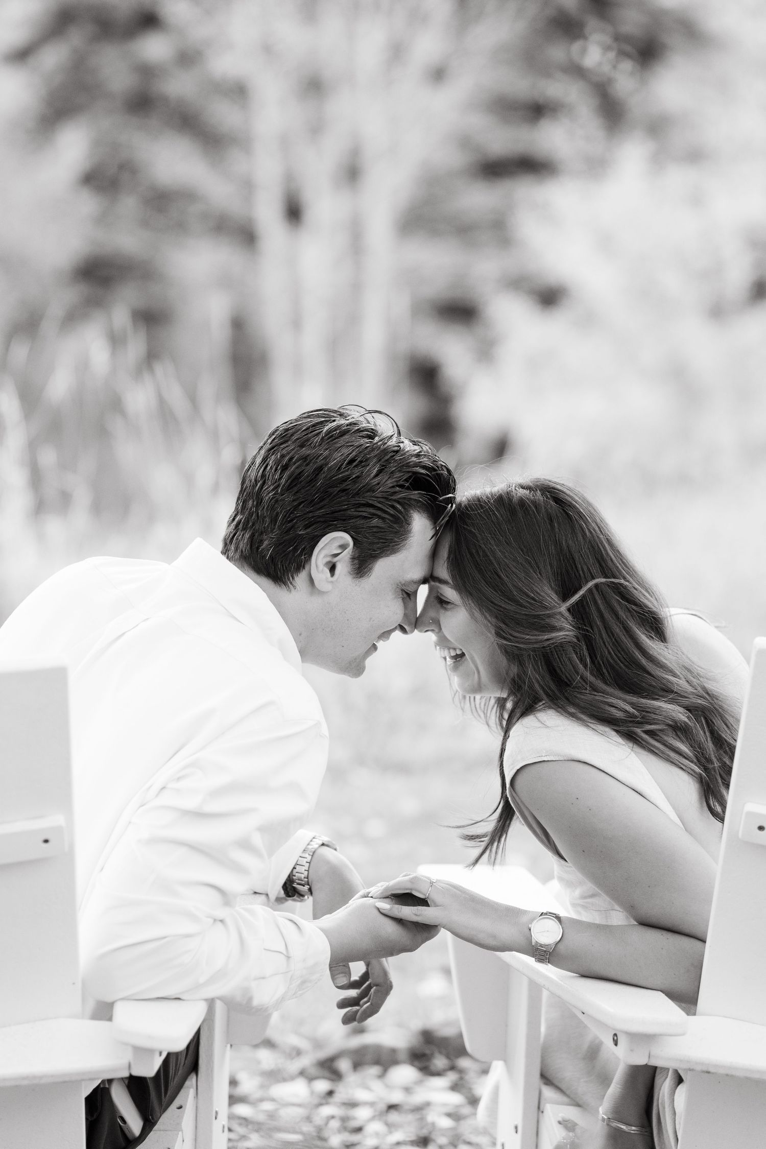 A romantic sequence showing a couple in white sharing tender kisses on garden chairs during vail proposal session.