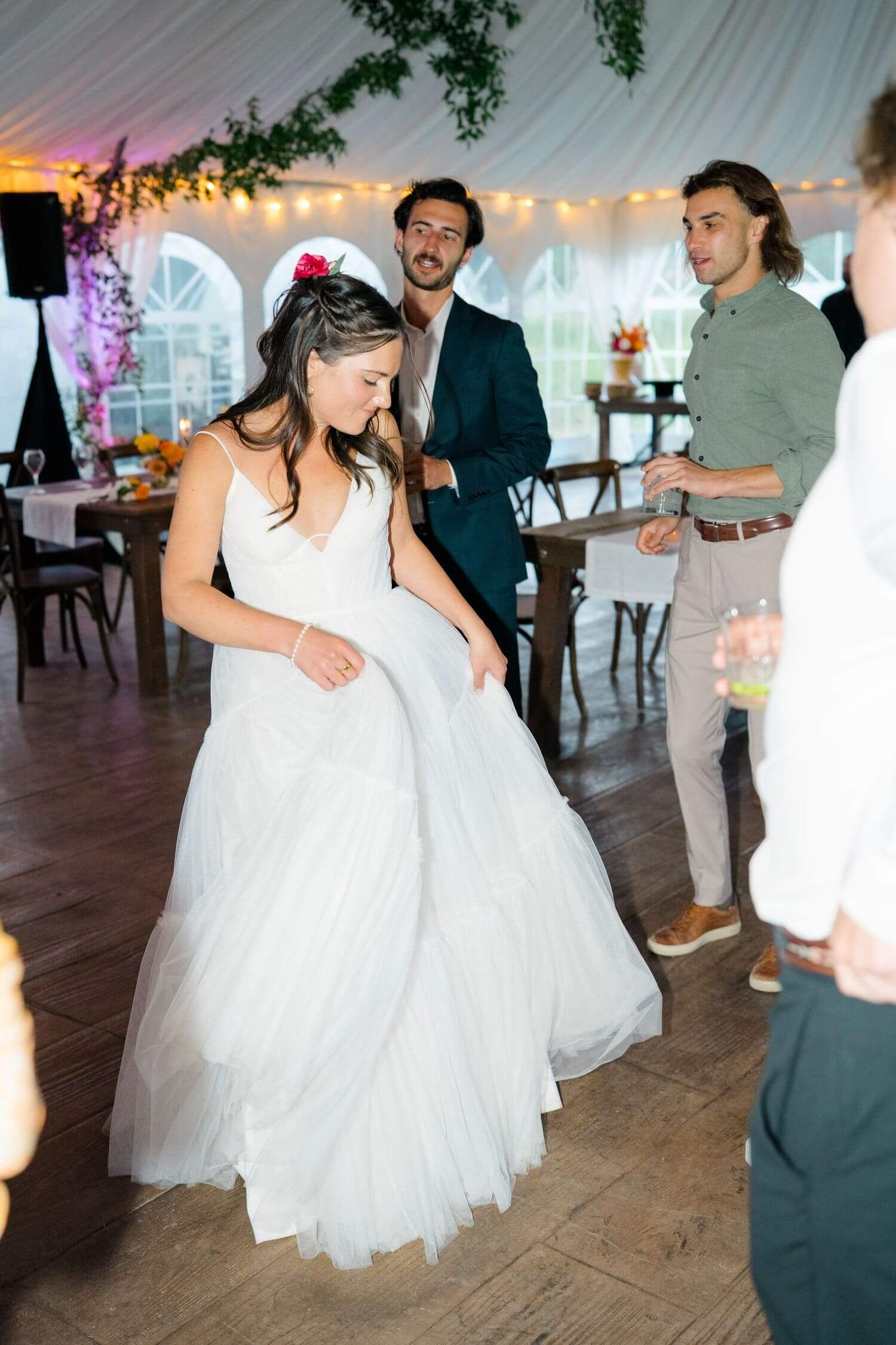 Camp Hale Wedding guests dancing and celebrating on a wooden dance floor under string lights at an evening reception.
