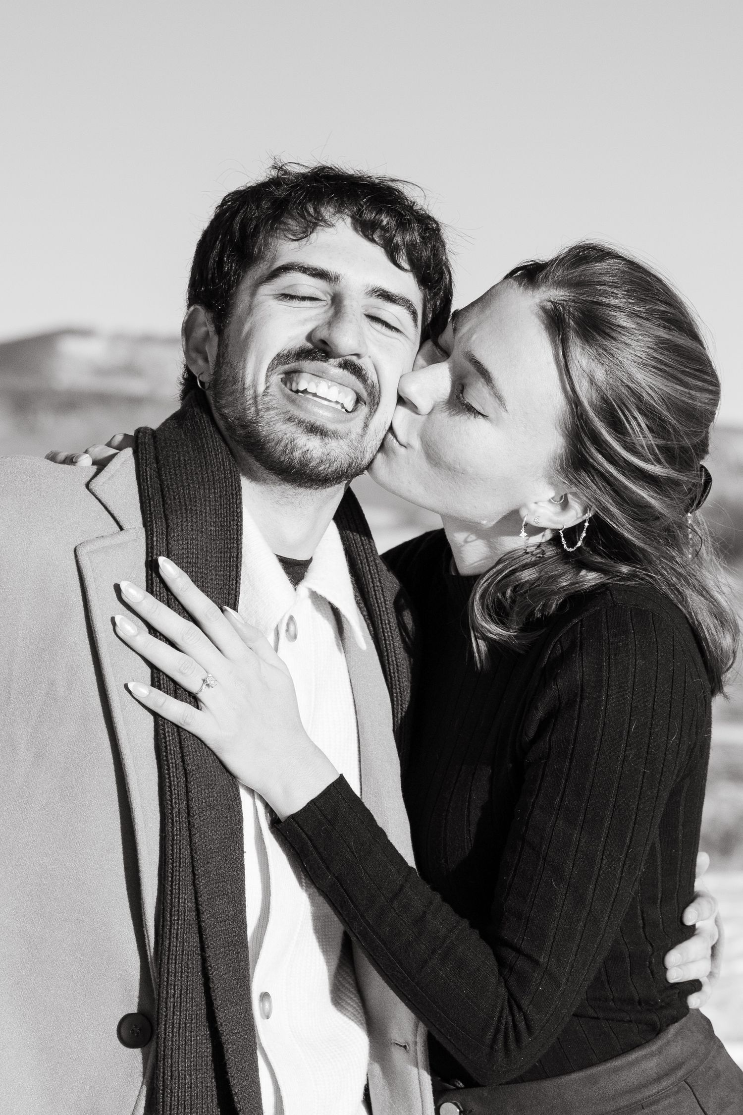 A romantic black and white photo series showing a couple embracing and sharing tender moments together.