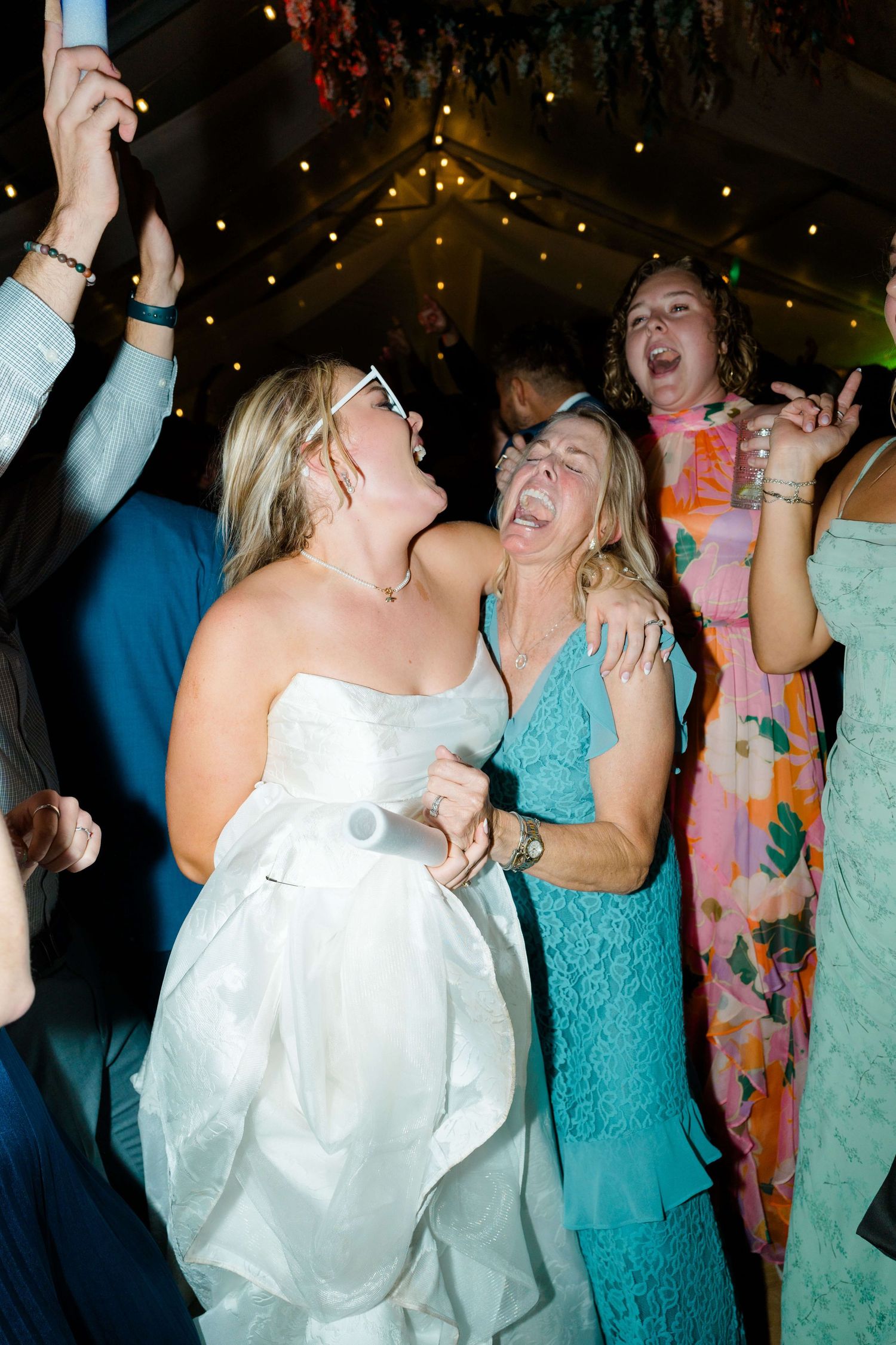 Wedding guests dancing and celebrating joyfully under twinkling lights at a reception party at vail wedding.