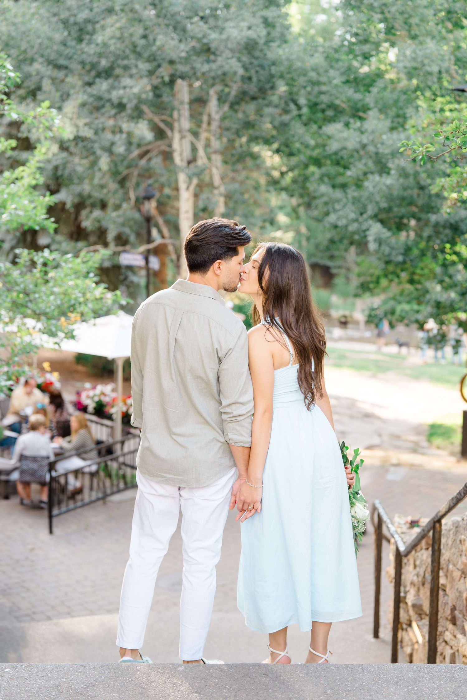 A couple in white outfits walking together on a path in a park setting, shown from four different angles after their vail village proposal