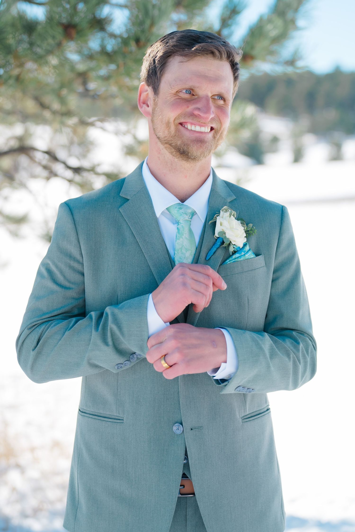 groom getting ready for wedding day folding cuffs of suit