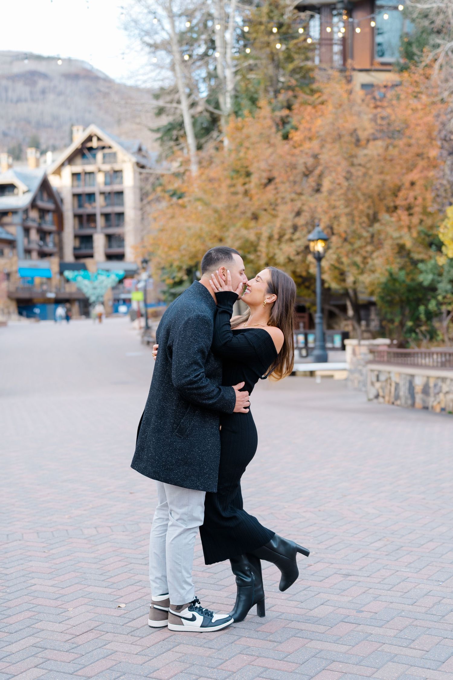 guy and girl kissing in vail village after getting engaged