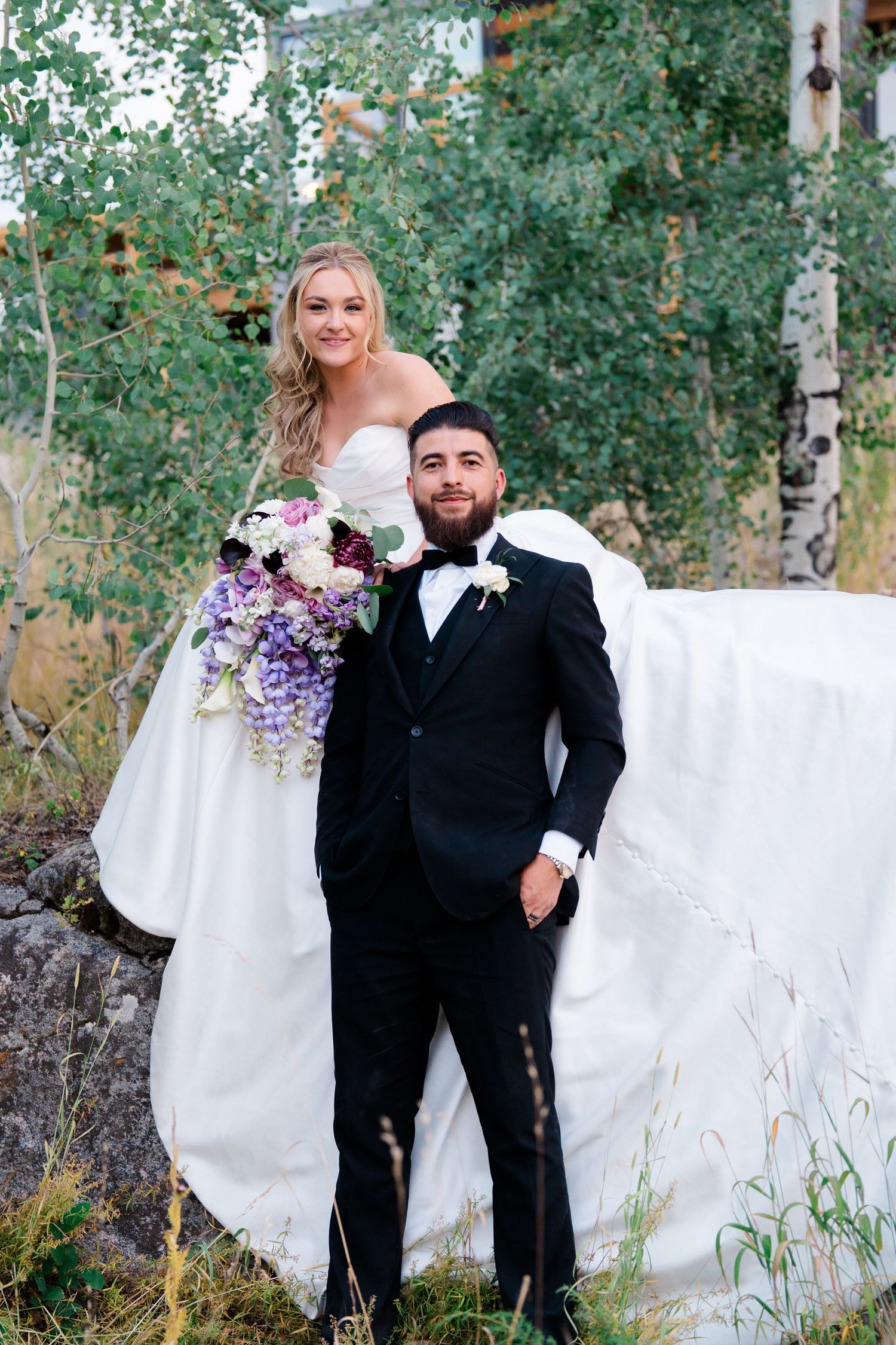 A romantic outdoor wedding photo series showing the couple posing together among aspen trees.