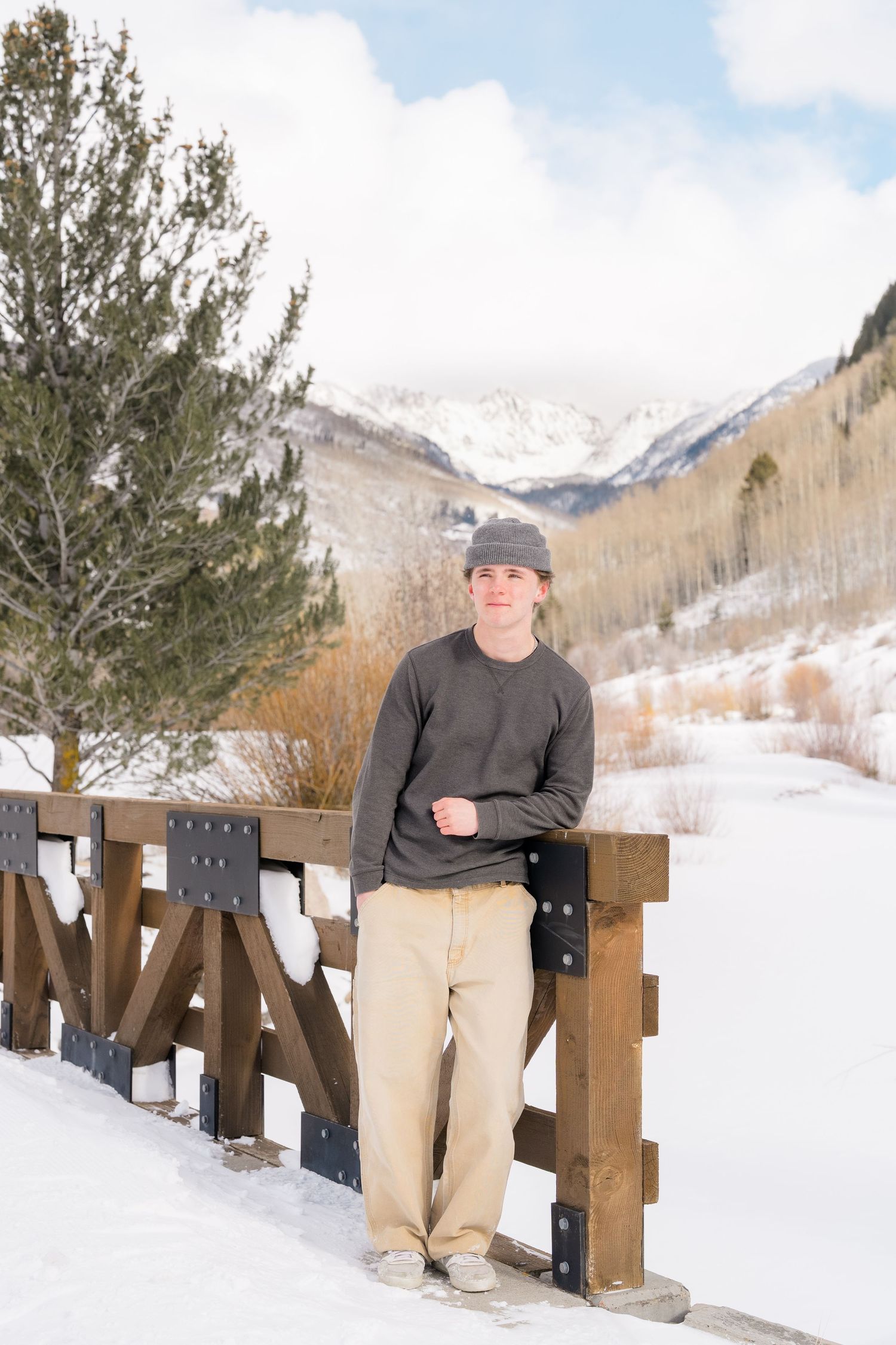 A snowy mountain landscape with a wooden fence running along a path in winter conditions.