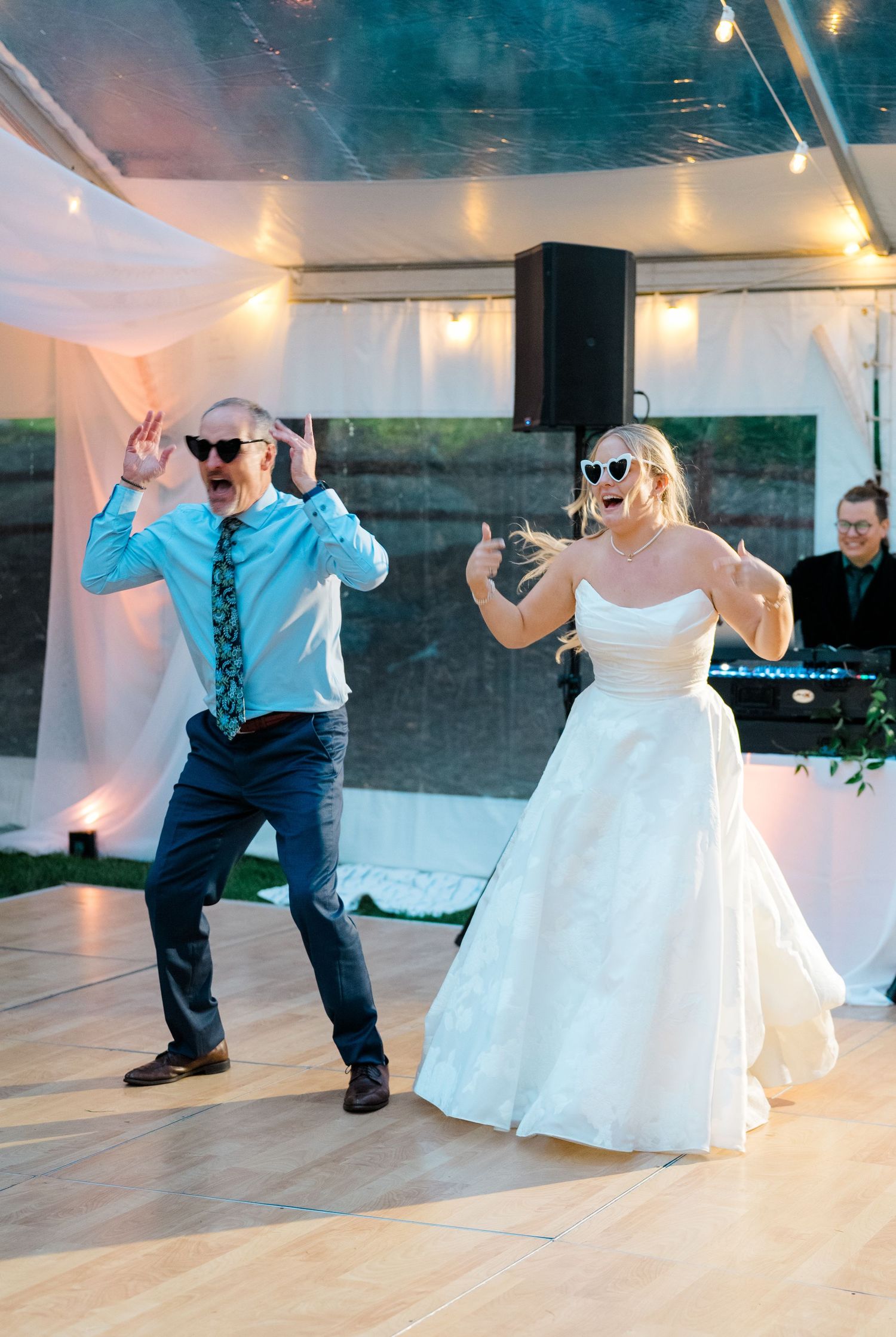 A fun dance sequence at a wedding reception shows guests in formal attire dancing energetically on a wooden floor.