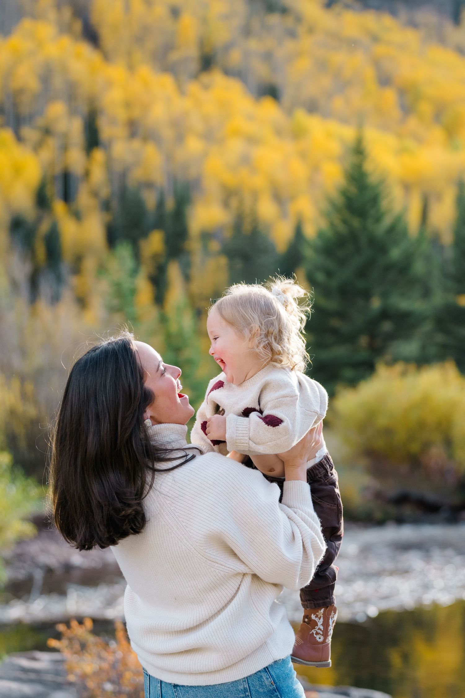 Playful moment captured between two people against autumn mountain landscape with golden aspens.