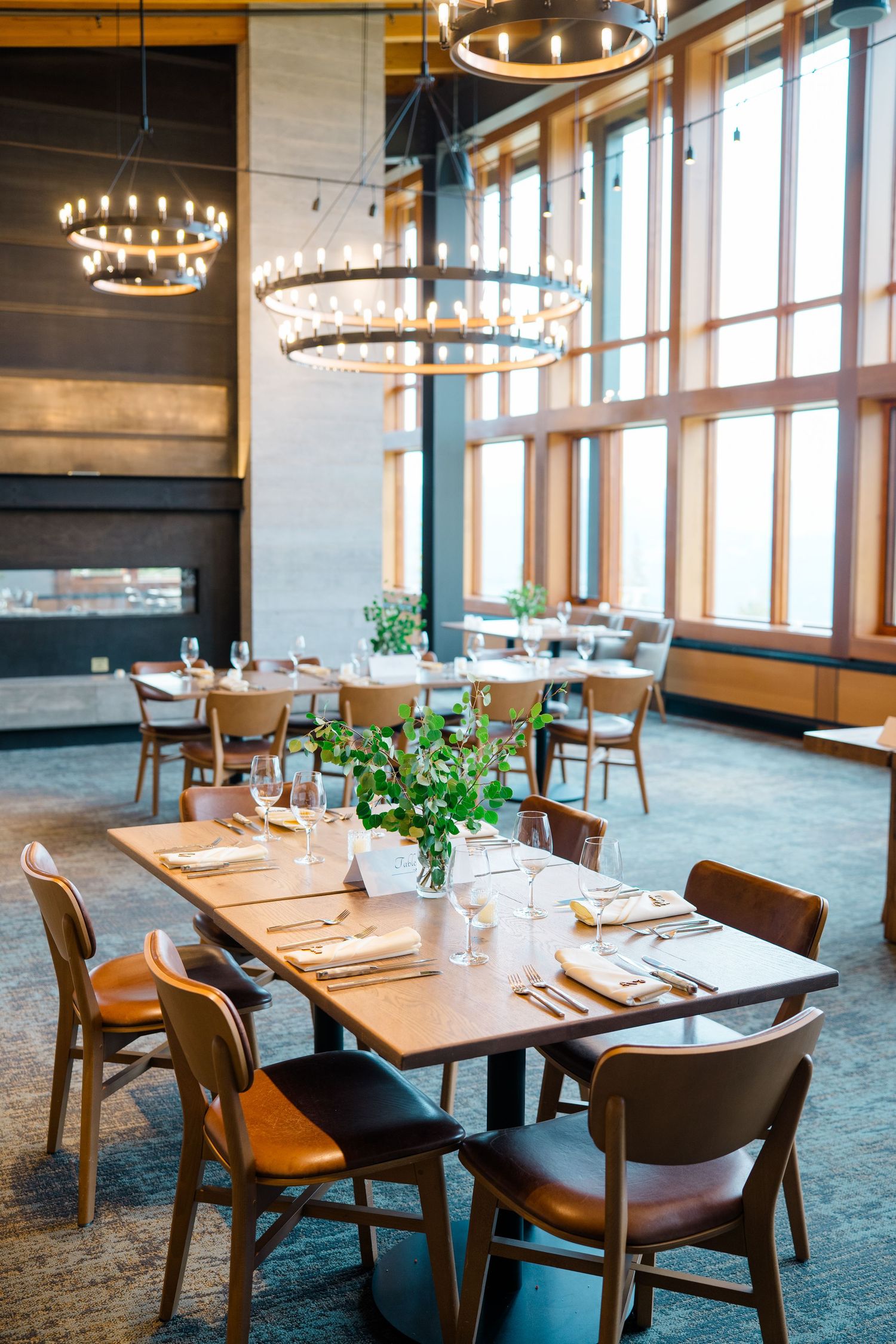 Modern interior with wooden tables, leather chairs and circular chandeliers creating an elegant dining atmosphere at copper mountain aerie.
