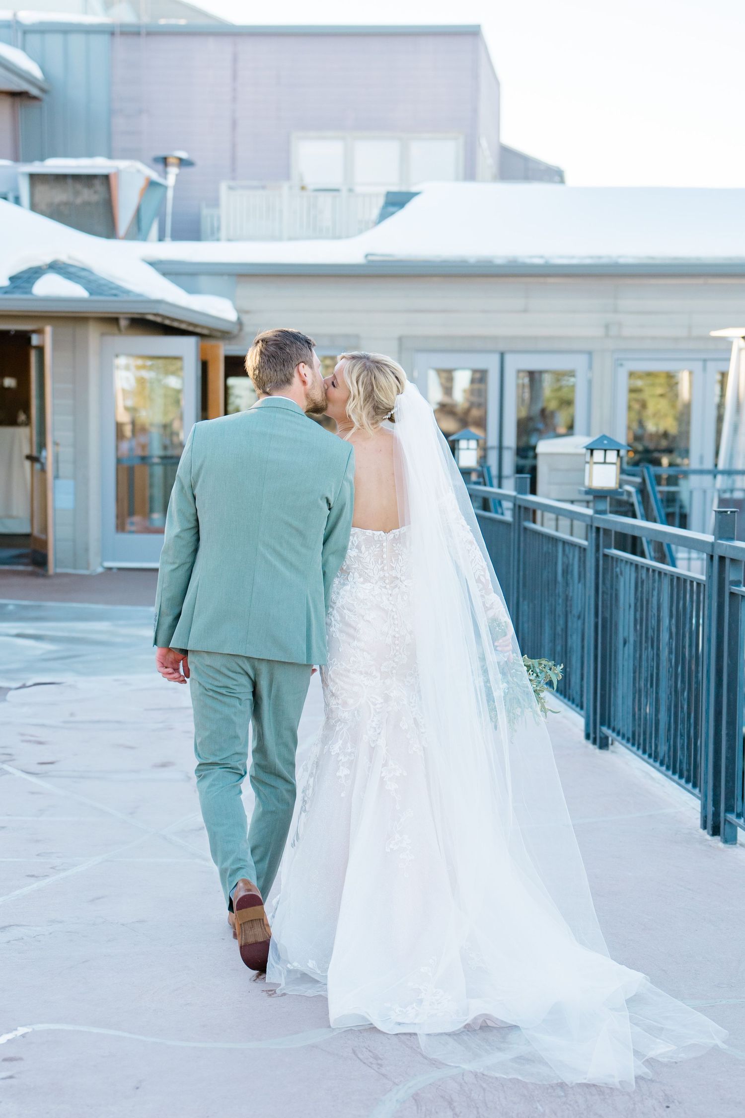 husband and wife kissing and walking away after wedding ceremony